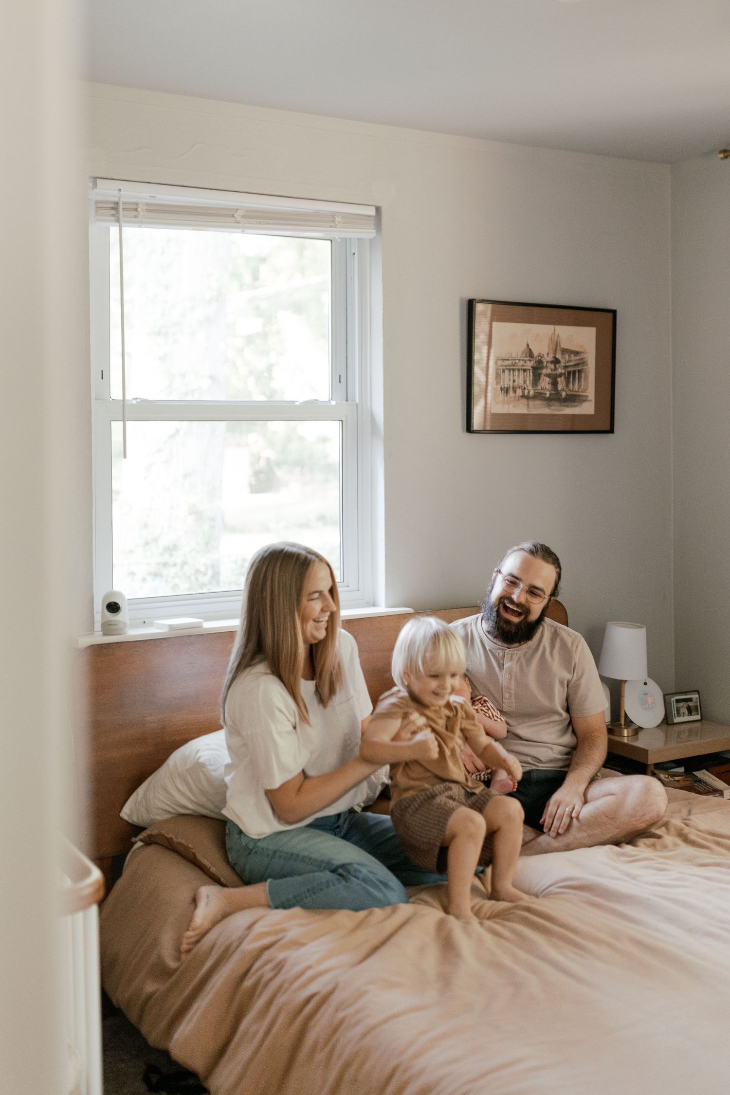 Family relaxing together on bed with golden retriever dog.