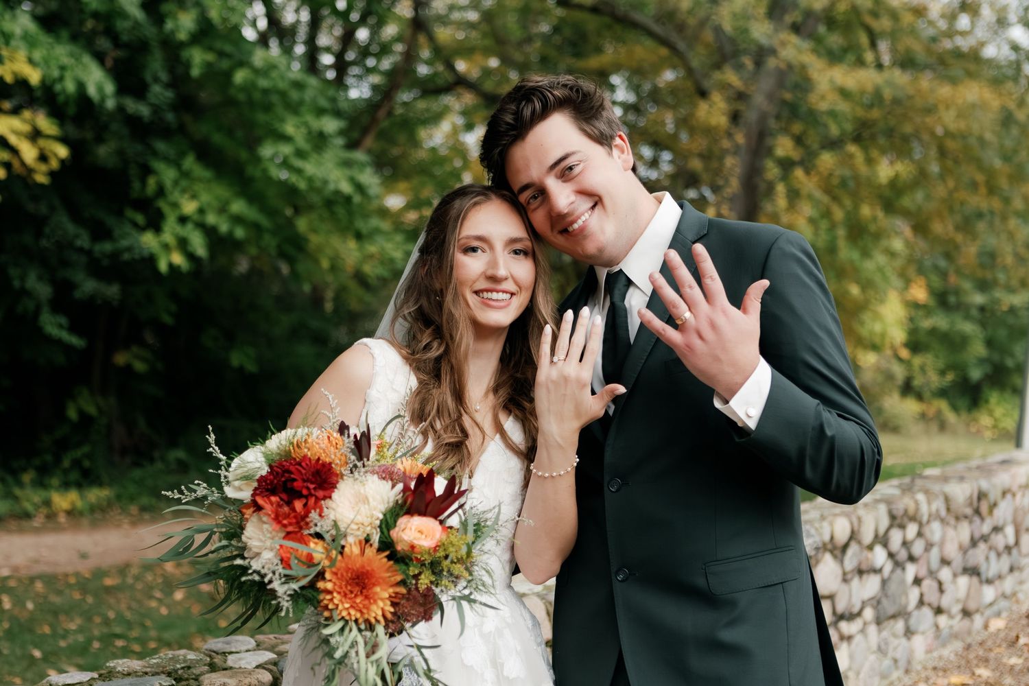 Autumn wedding portraits taken outdoors with vibrant fall foliage in background.