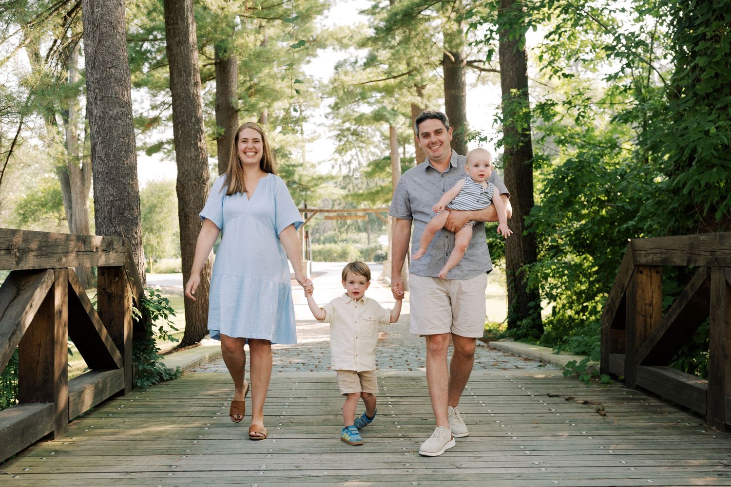 Family walking together on a wooden boardwalk through a scenic outdoor setting.