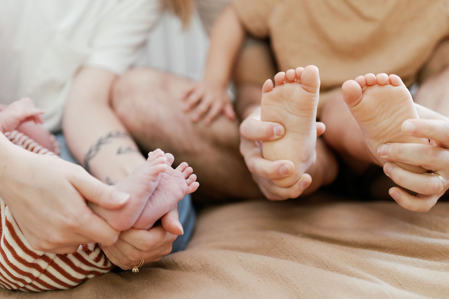 Close-up details of baby feet and gentle touches in black and white.