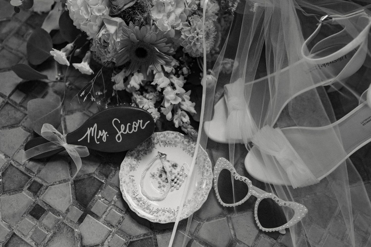 Black and white wedding detail shots featuring a veil and accessories.