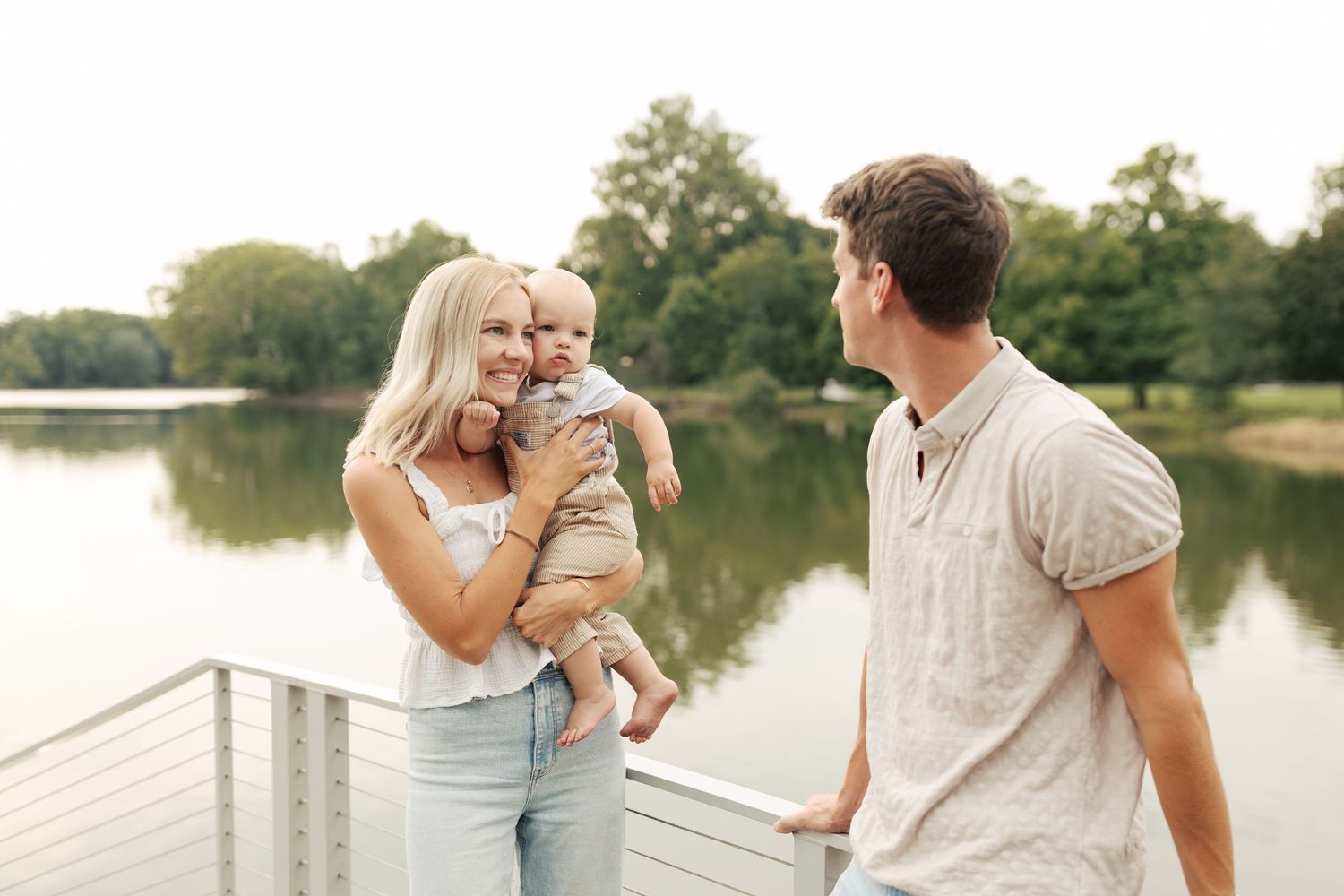 Family enjoys peaceful moment together by lakeside during summer evening.