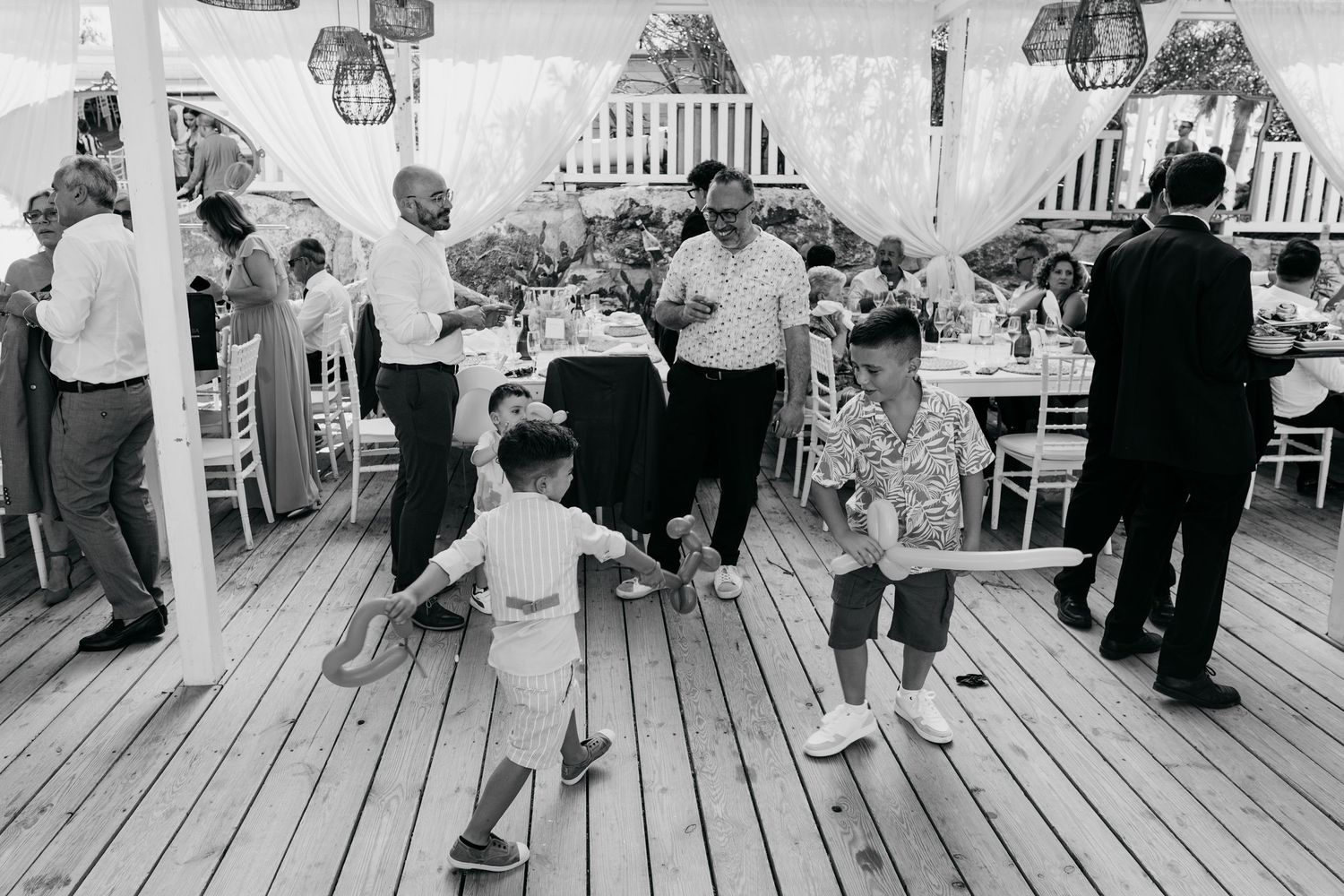 Black and white photo showing a group of people gathered on a wooden boardwalk.