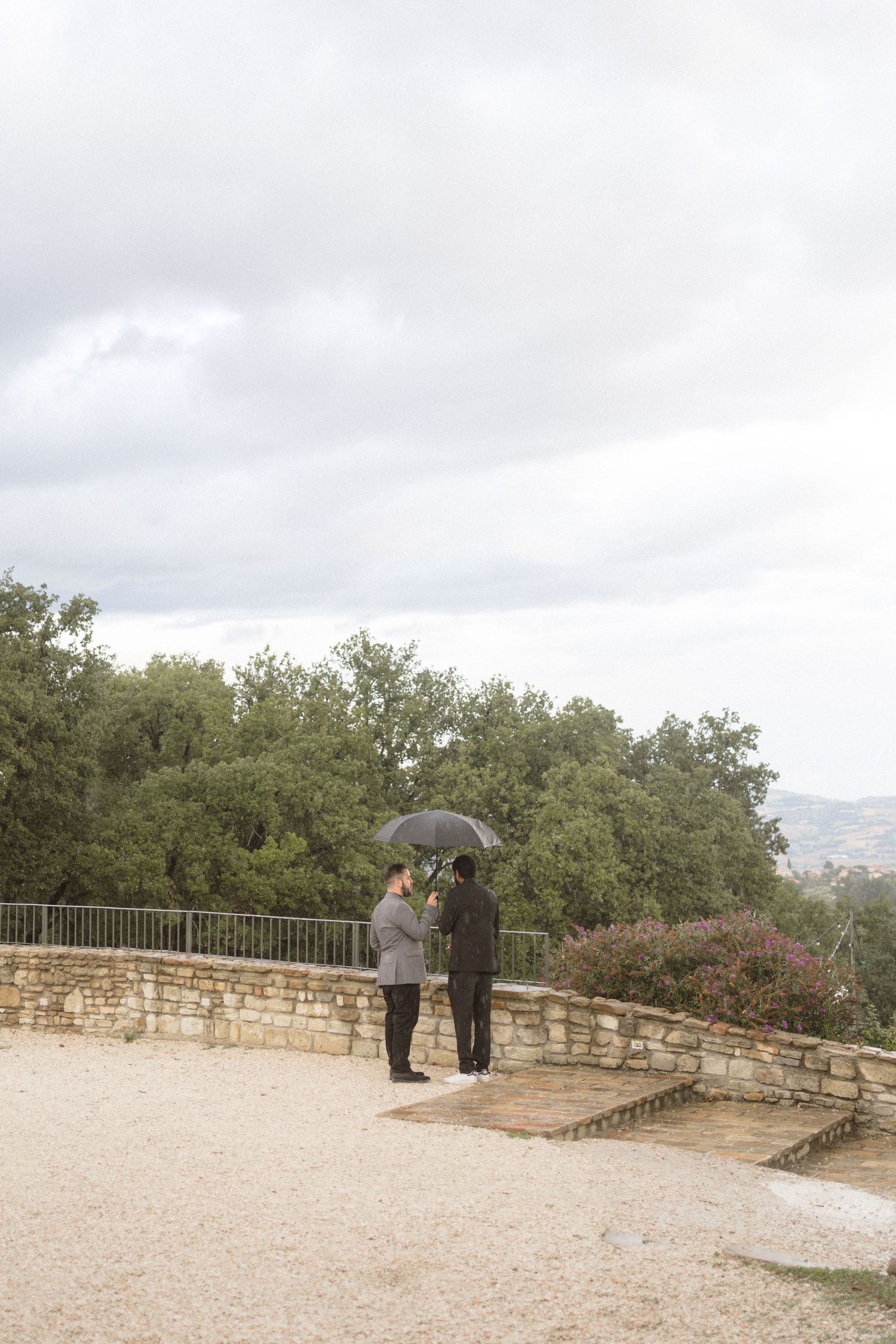 A stone overlook platform surrounded by trees provides a scenic outdoor wedding venue.