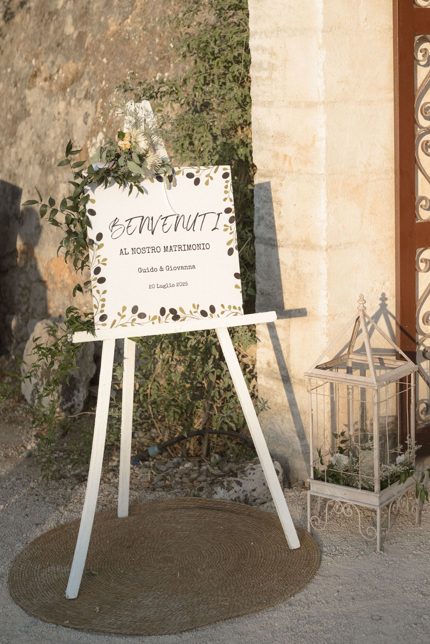 Welcome signs on white easels displayed at an outdoor wedding venue entrance.