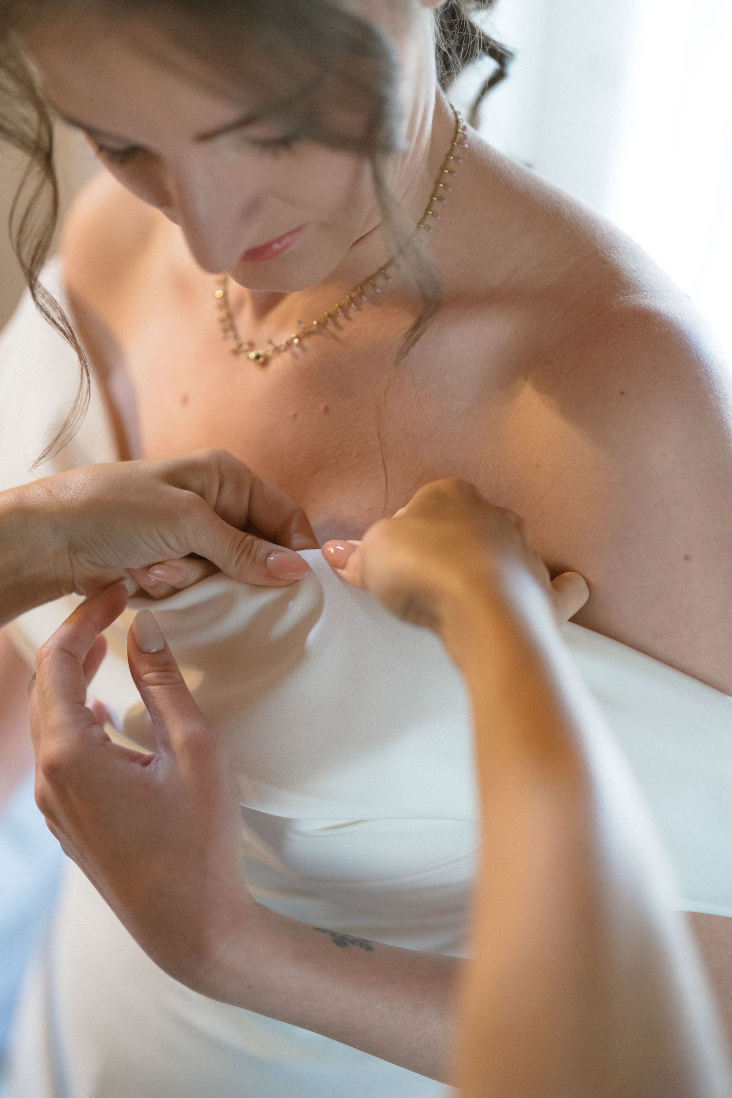 Close-up detail shots of wedding dress adjustments and final preparations.