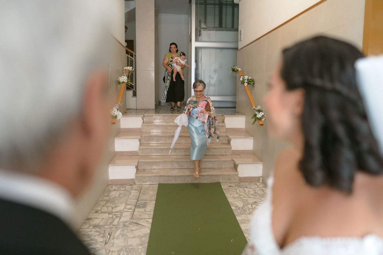 Wedding ceremony venue with a green carpet aisle runner leading to an elegant entrance.