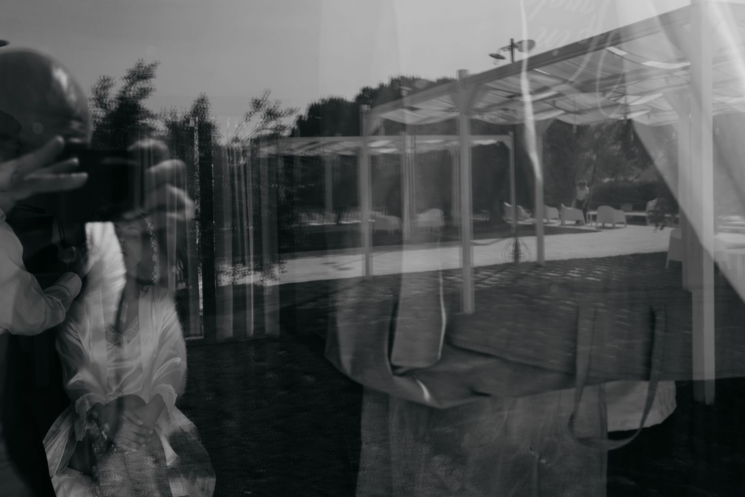 Double exposure black and white photograph showing architectural elements and reflections.