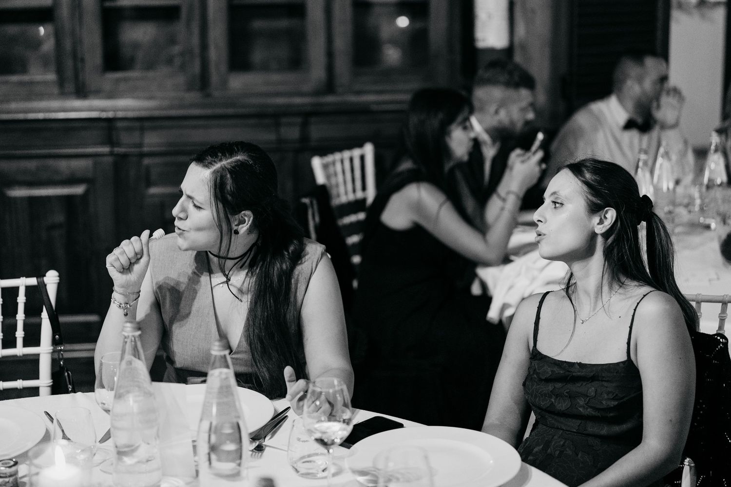 Black and white photo series showing guests enjoying a celebratory meal at a restaurant or dining event.