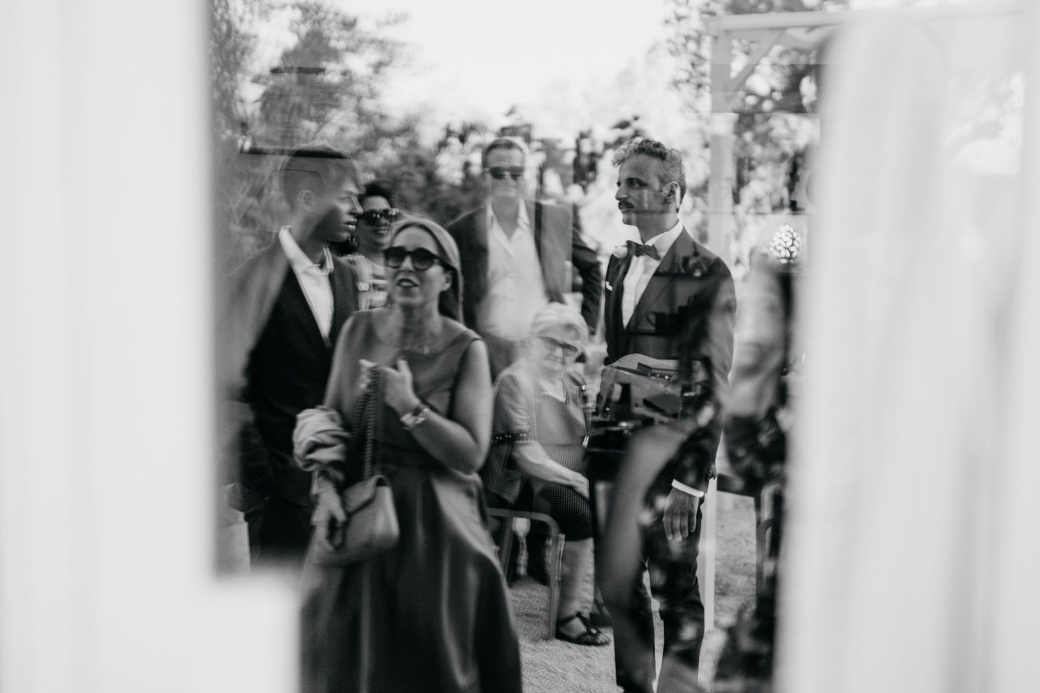 Black and white snapshot of wedding guests during outdoor celebration.