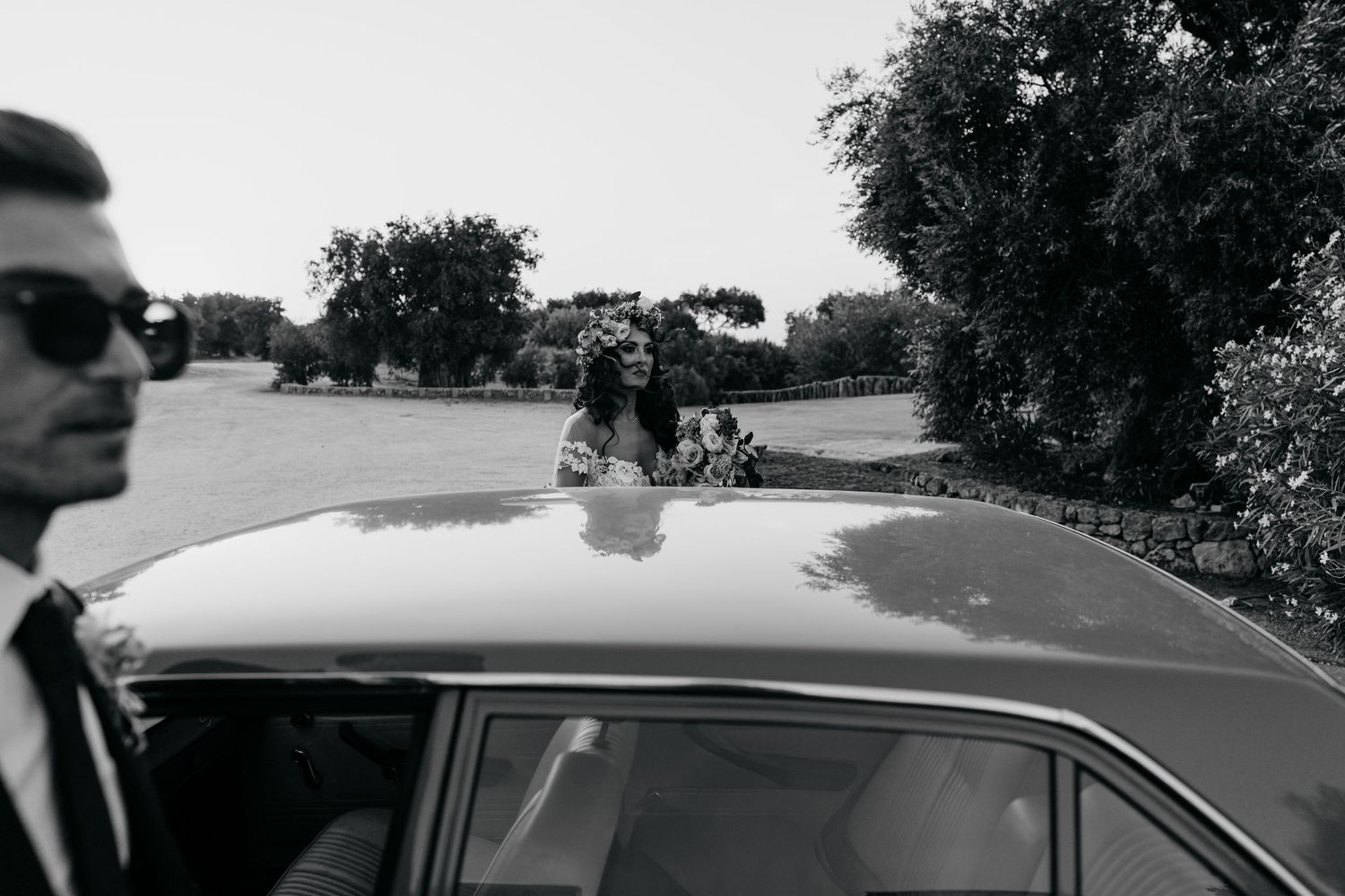 Classic car details and roofline silhouettes against a cloudy sky.