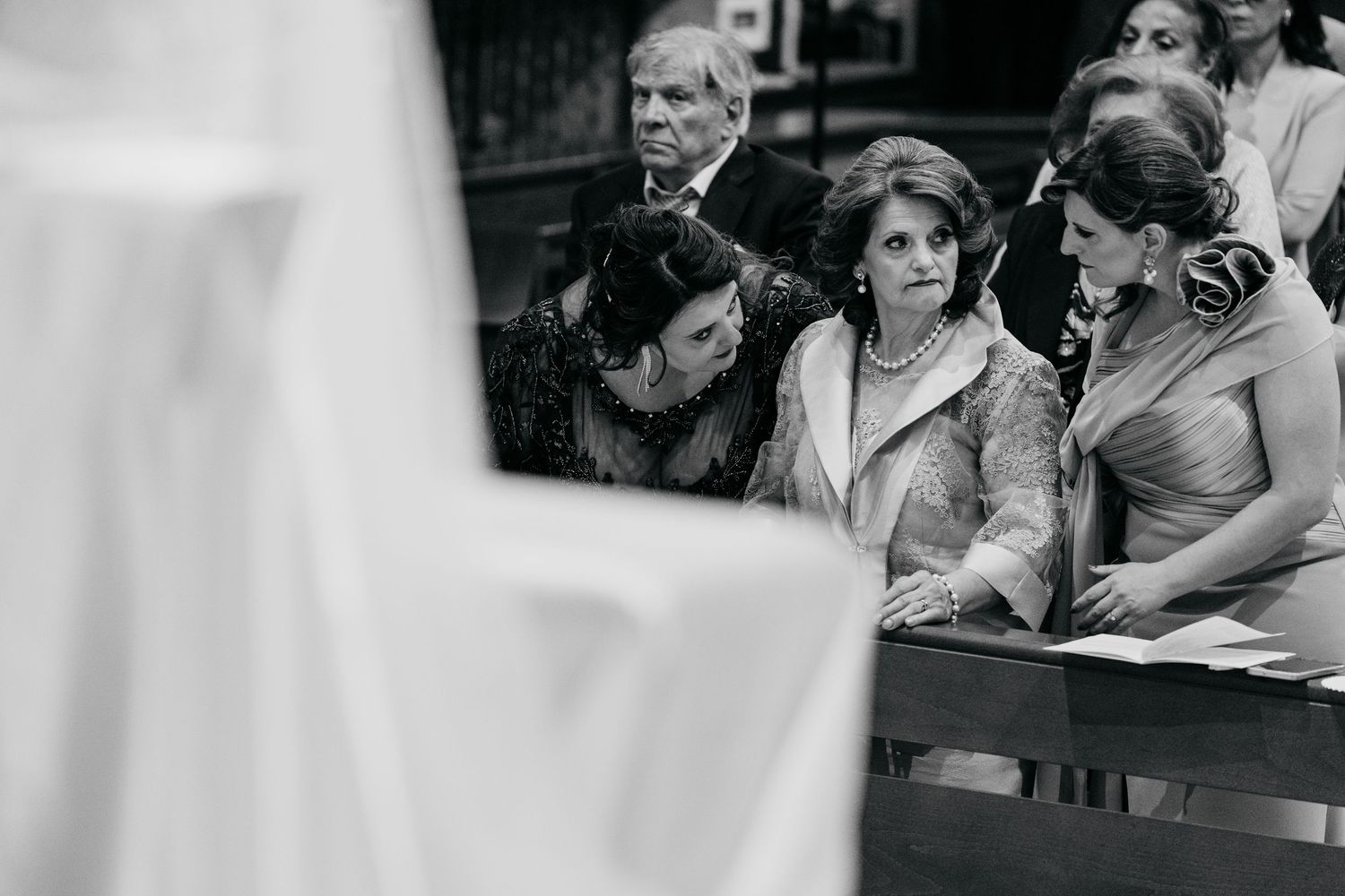 Black and white candid shots of wedding guests watching ceremony with emotional expressions.