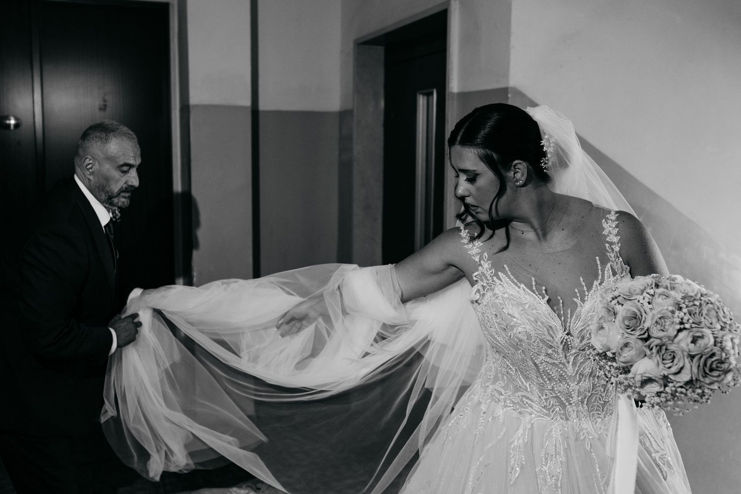 An intimate moment as a wedding dress is adjusted before the ceremony.