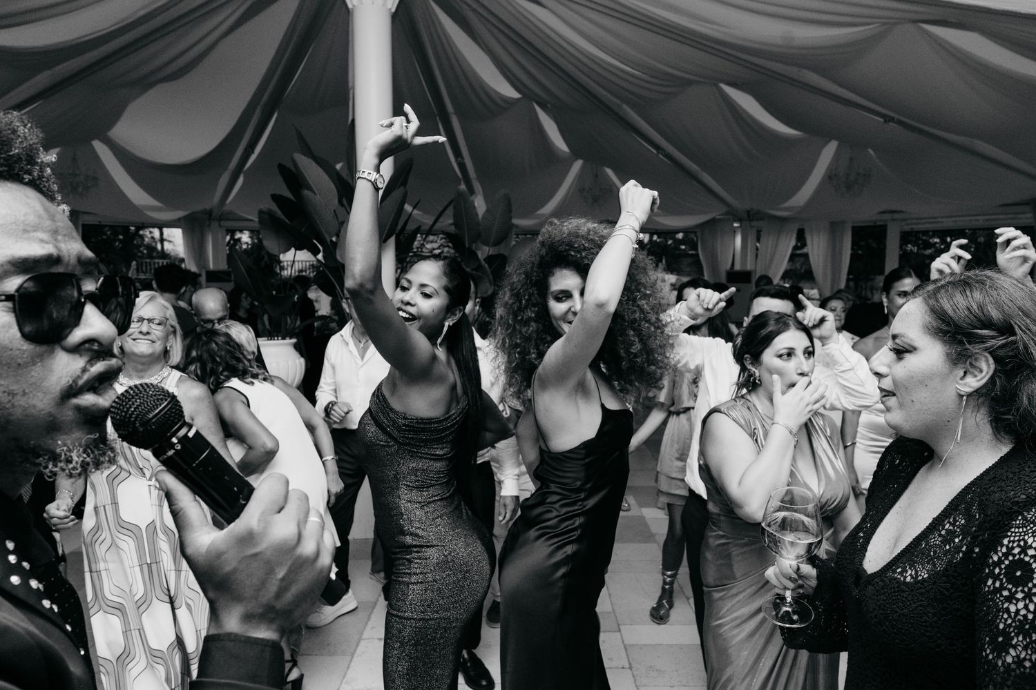 Black and white photo of a lively dance party with people celebrating on a crowded dance floor.
