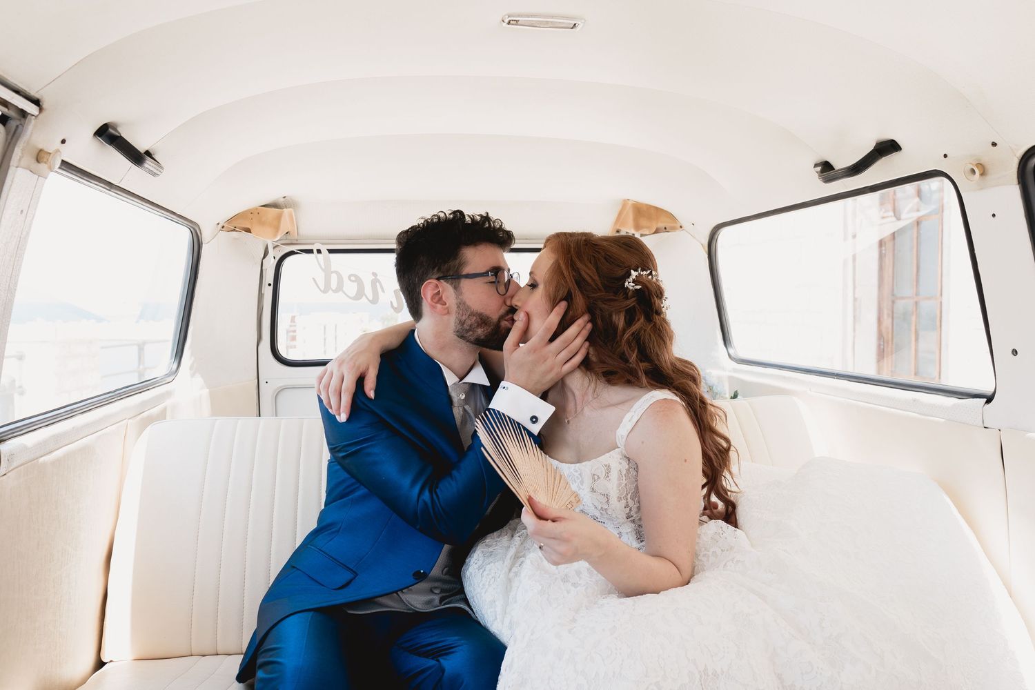 Romantic moment captured inside vintage Volkswagen van with white interior.