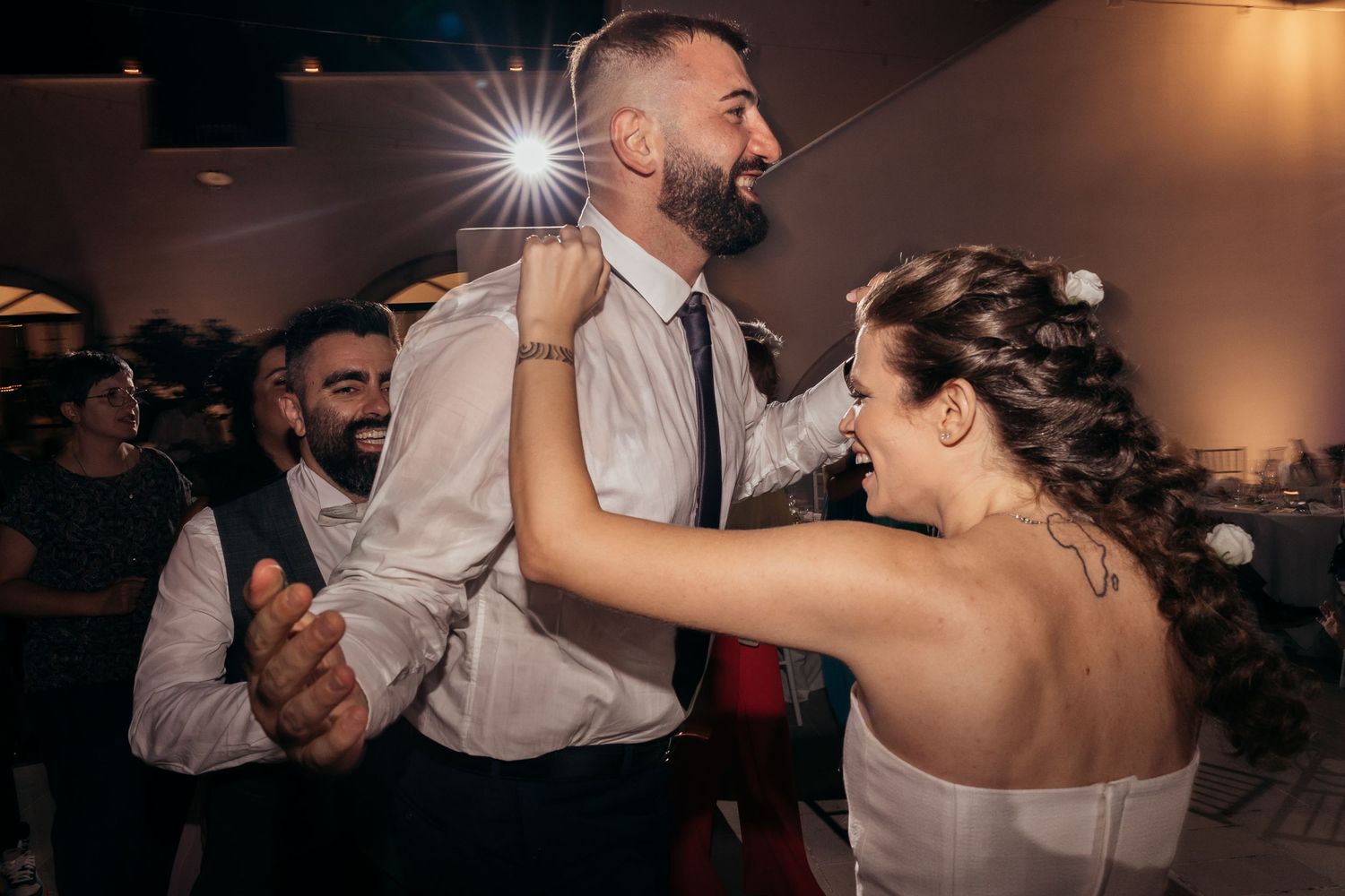 A couple dances energetically together during their wedding reception celebration.