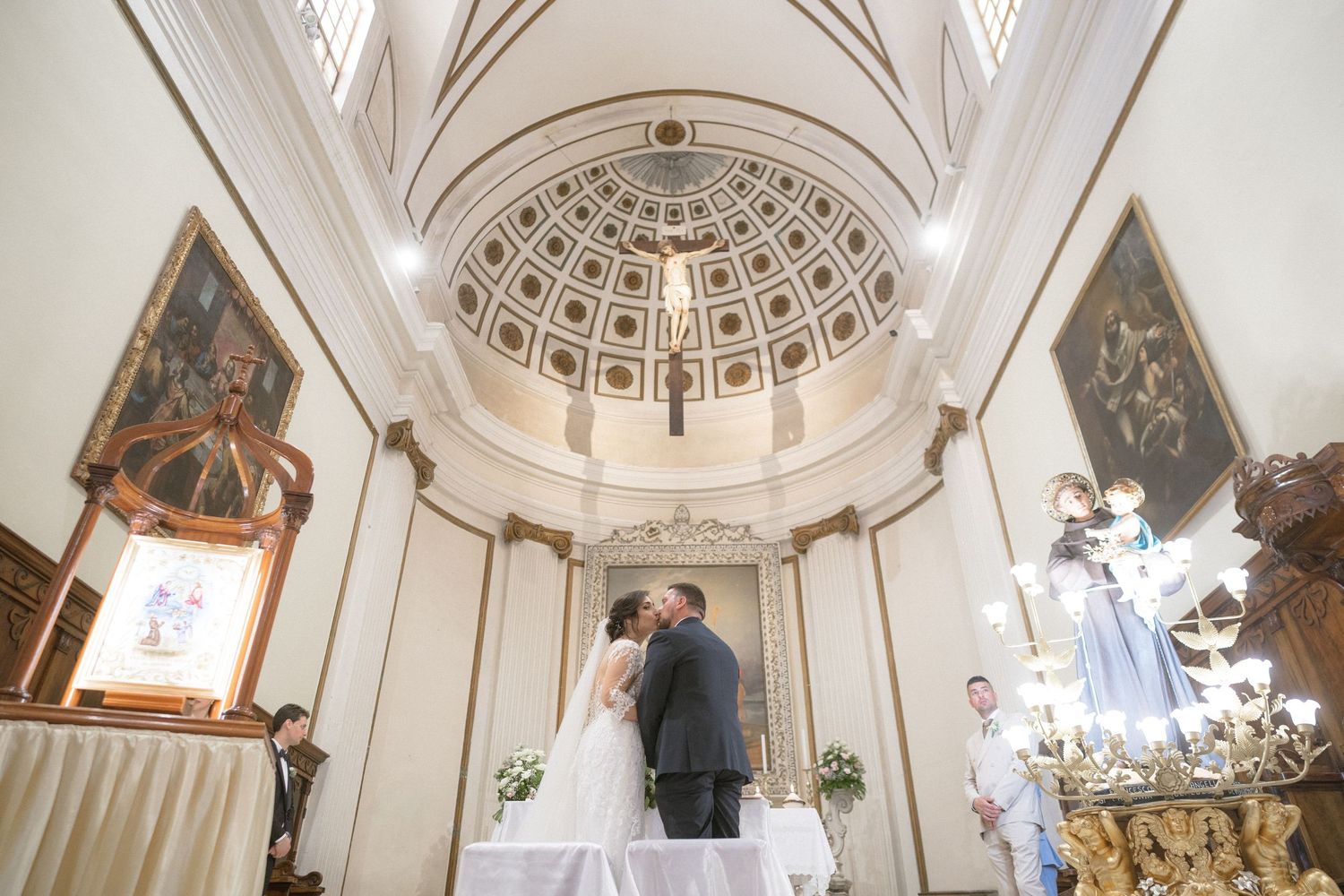 Interior of a grand cathedral with vaulted ceilings, dome architecture and religious artwork.