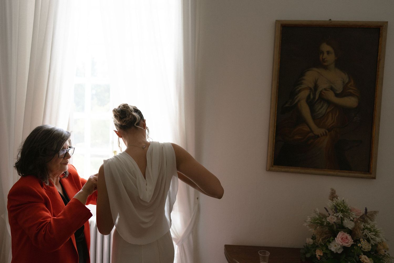 Wedding ceremony venue with white curtains and artwork on display.