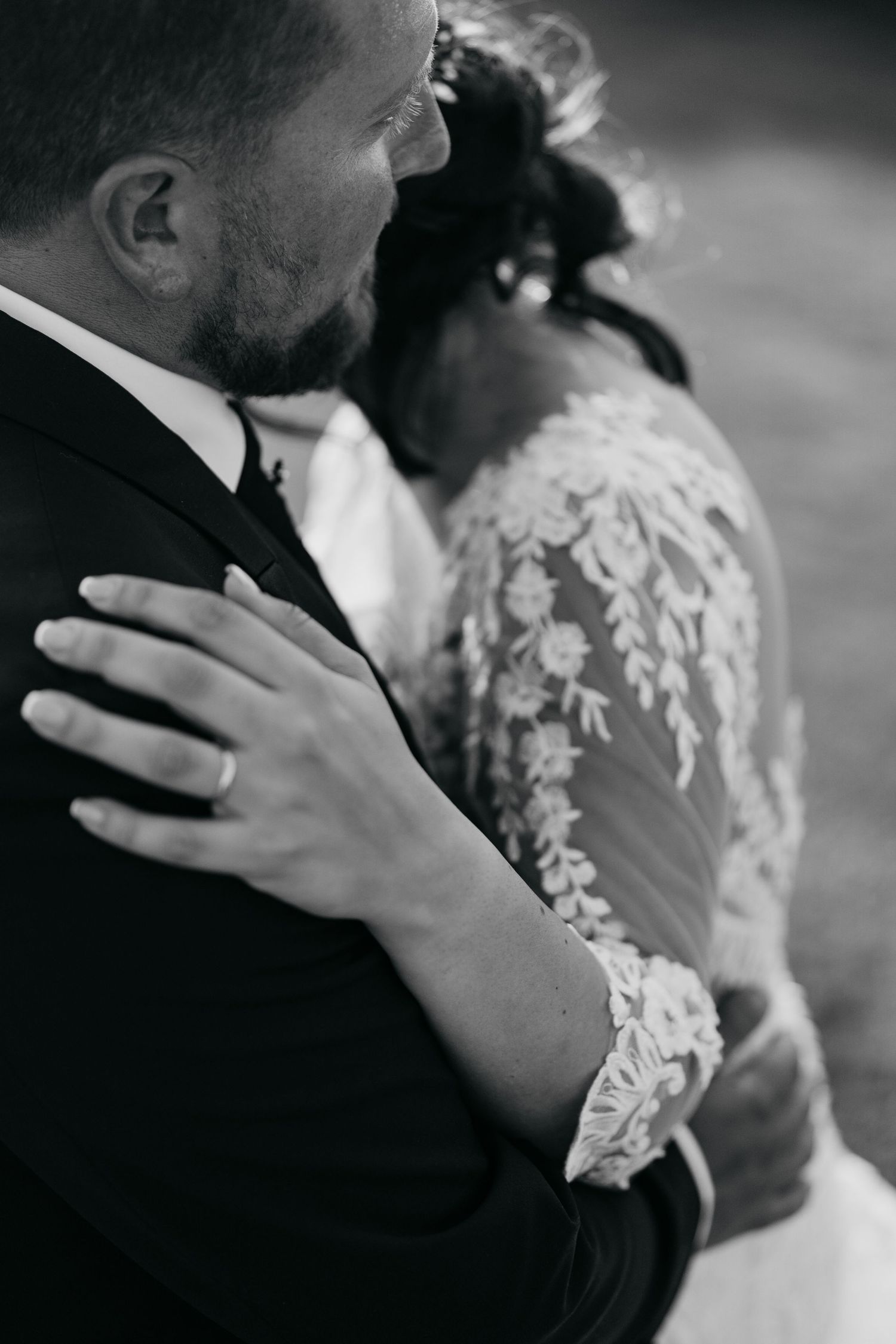 Intimate black and white shots of a couple embracing during their wedding ceremony.