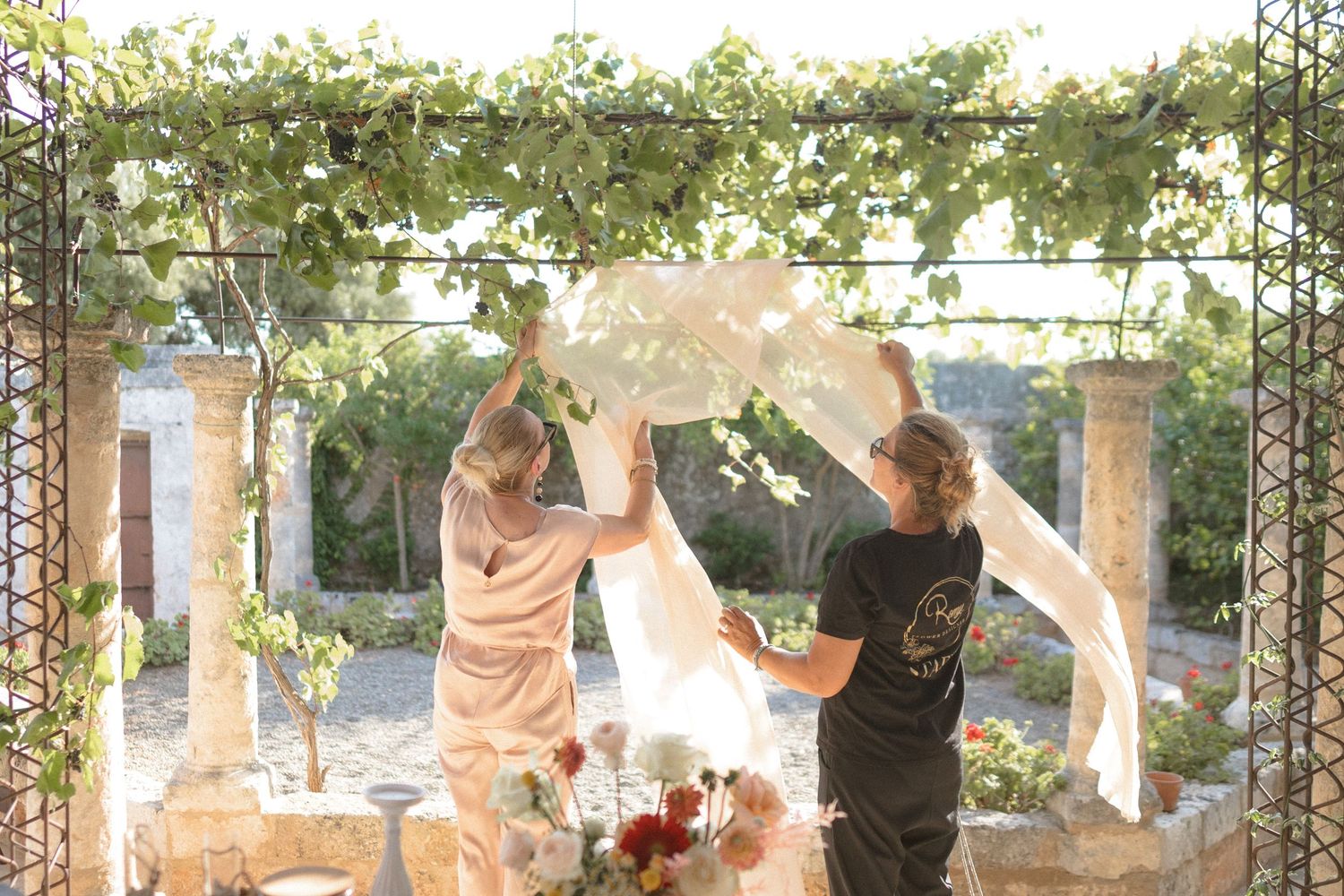 Outdoor wedding venue with string lights and natural greenery overhead.