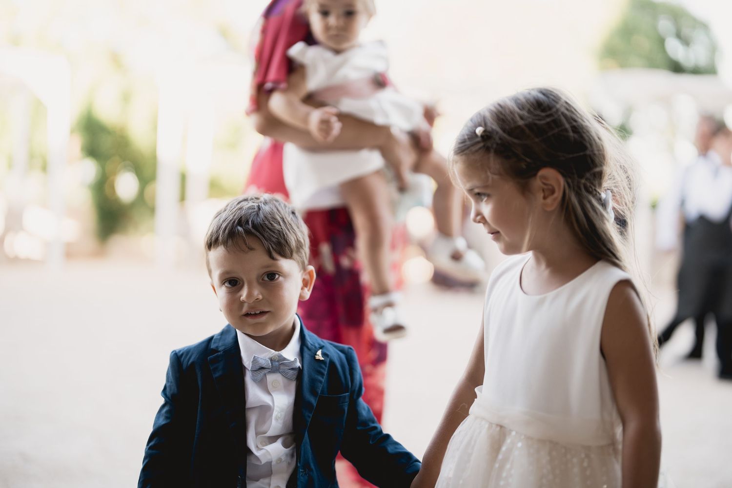 Children in formal attire walking together at an elegant event.