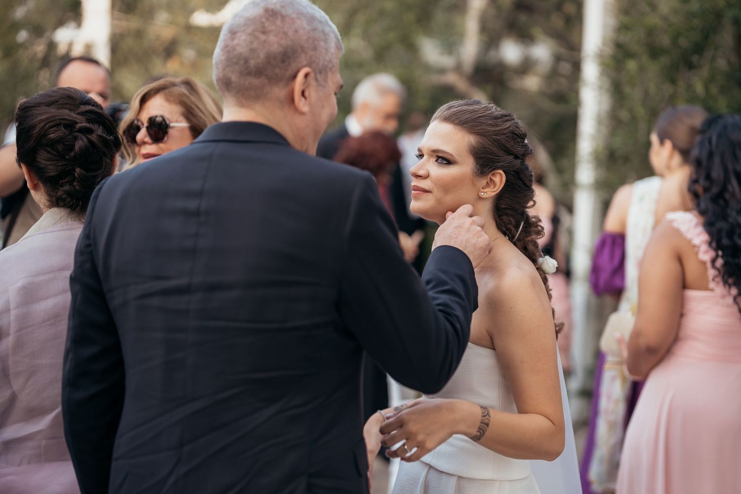 Wedding reception gathering with guests in formal attire mingling outdoors.