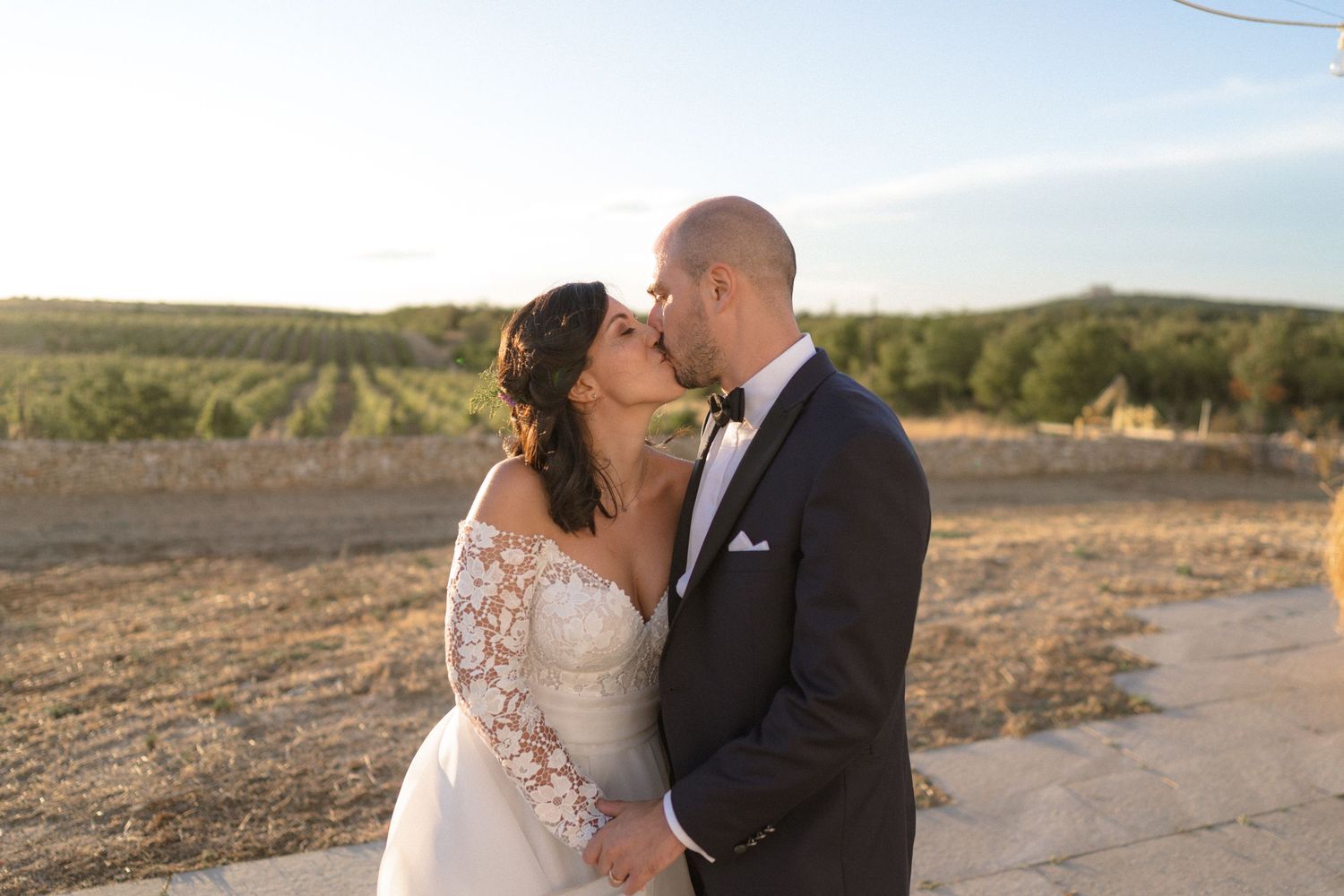 Romantic sunset wedding portraits in a rustic vineyard setting.