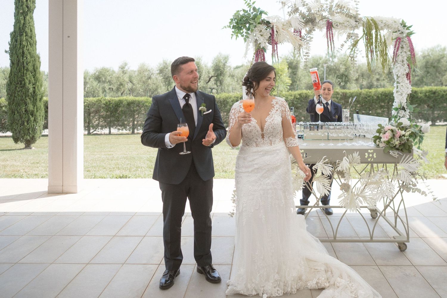 Wedding party celebrating on an outdoor patio with elegant decor and natural lighting.