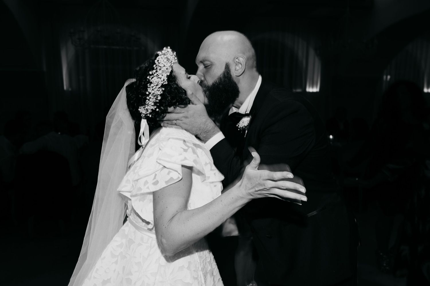 A romantic black and white wedding photo captures a couple's intimate dance moment.