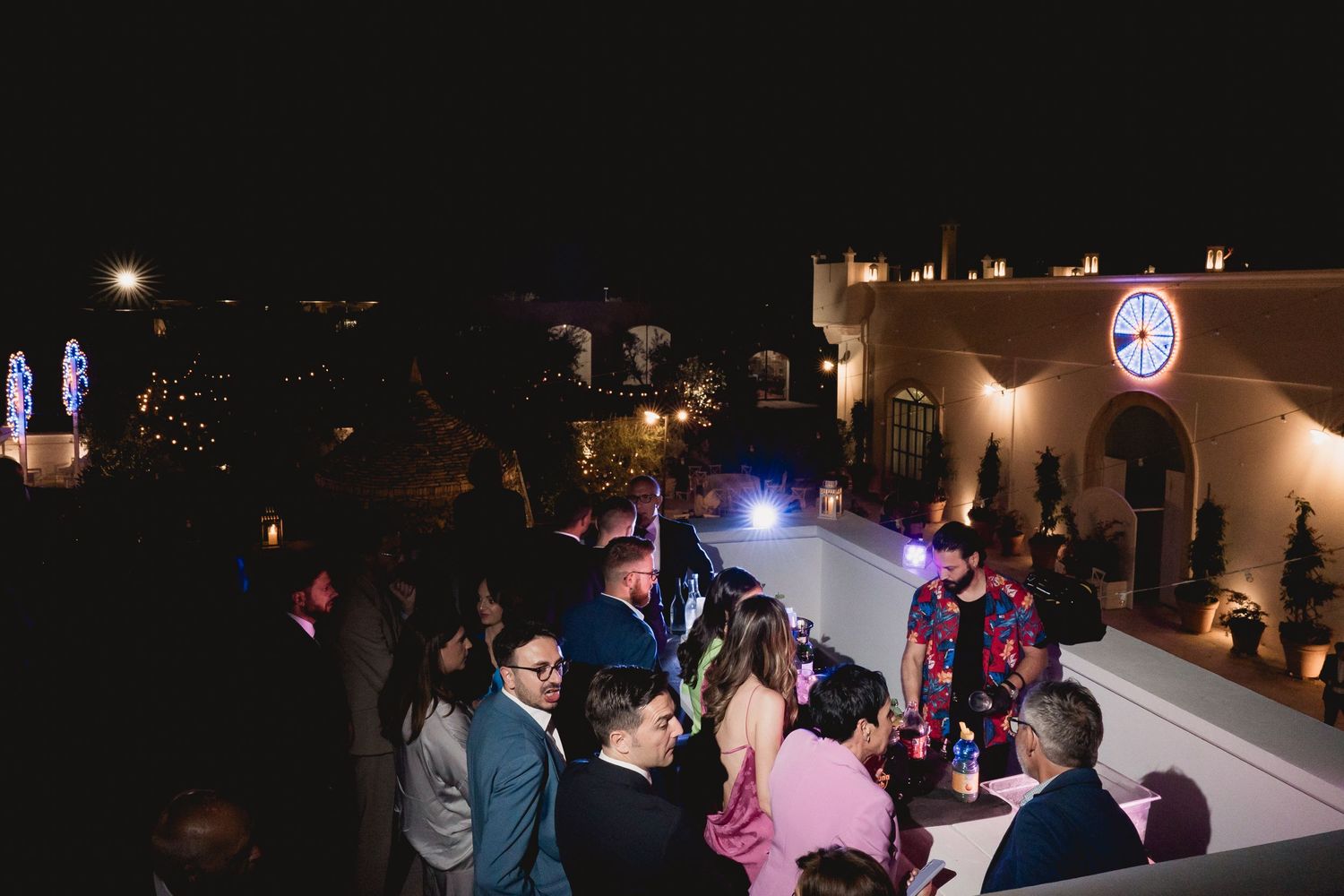Nighttime rooftop celebration with people dancing under ambient lighting.