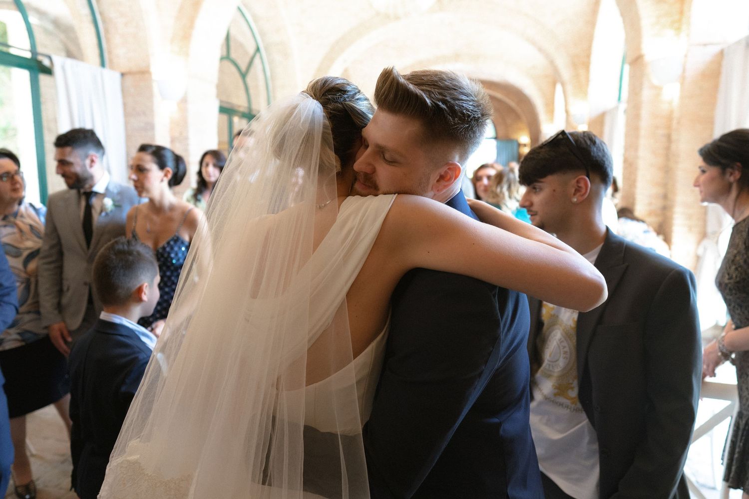 Wedding celebration in a bright indoor venue with stone arches.