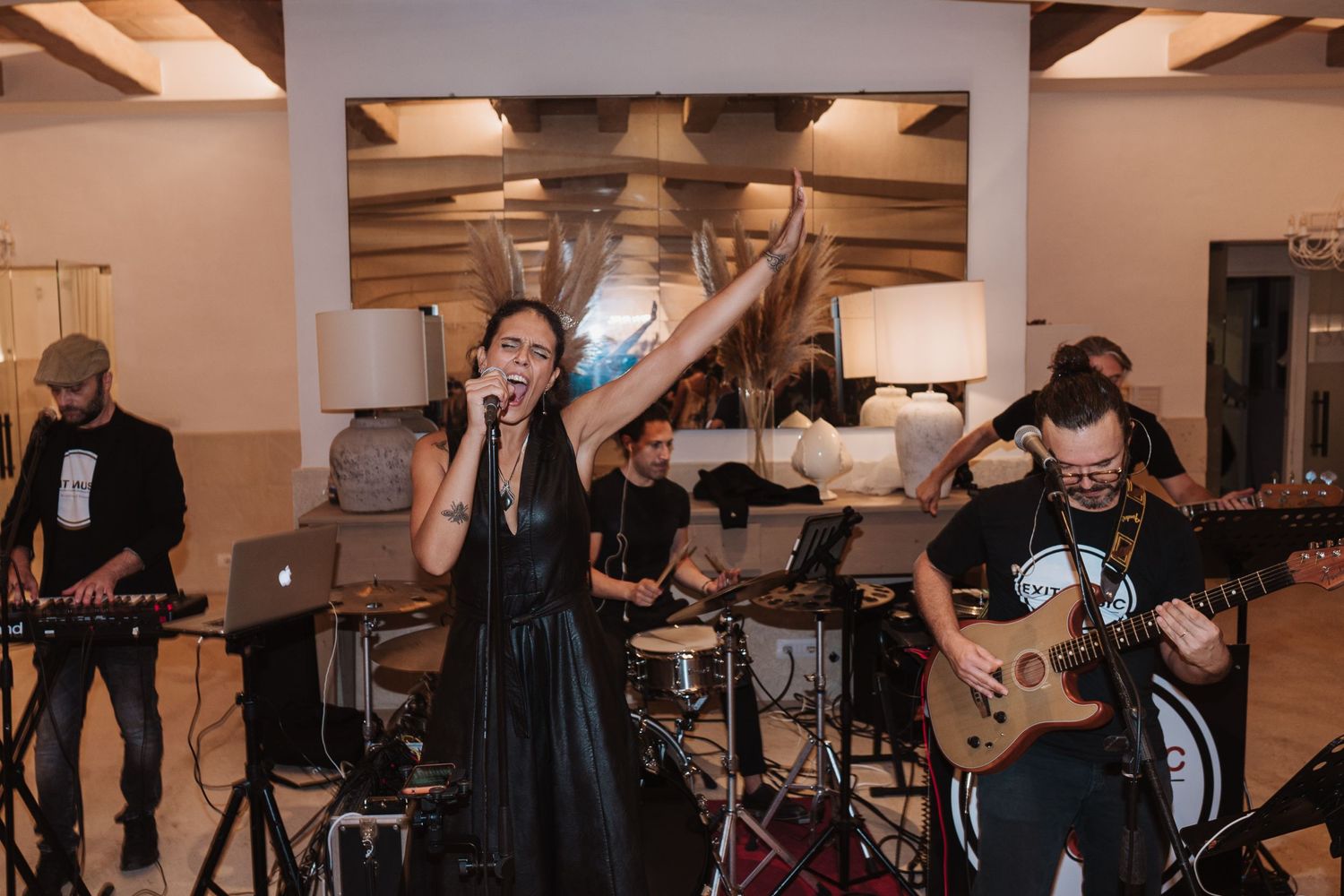 Live wedding band performs energetically with musicians playing instruments on stage.