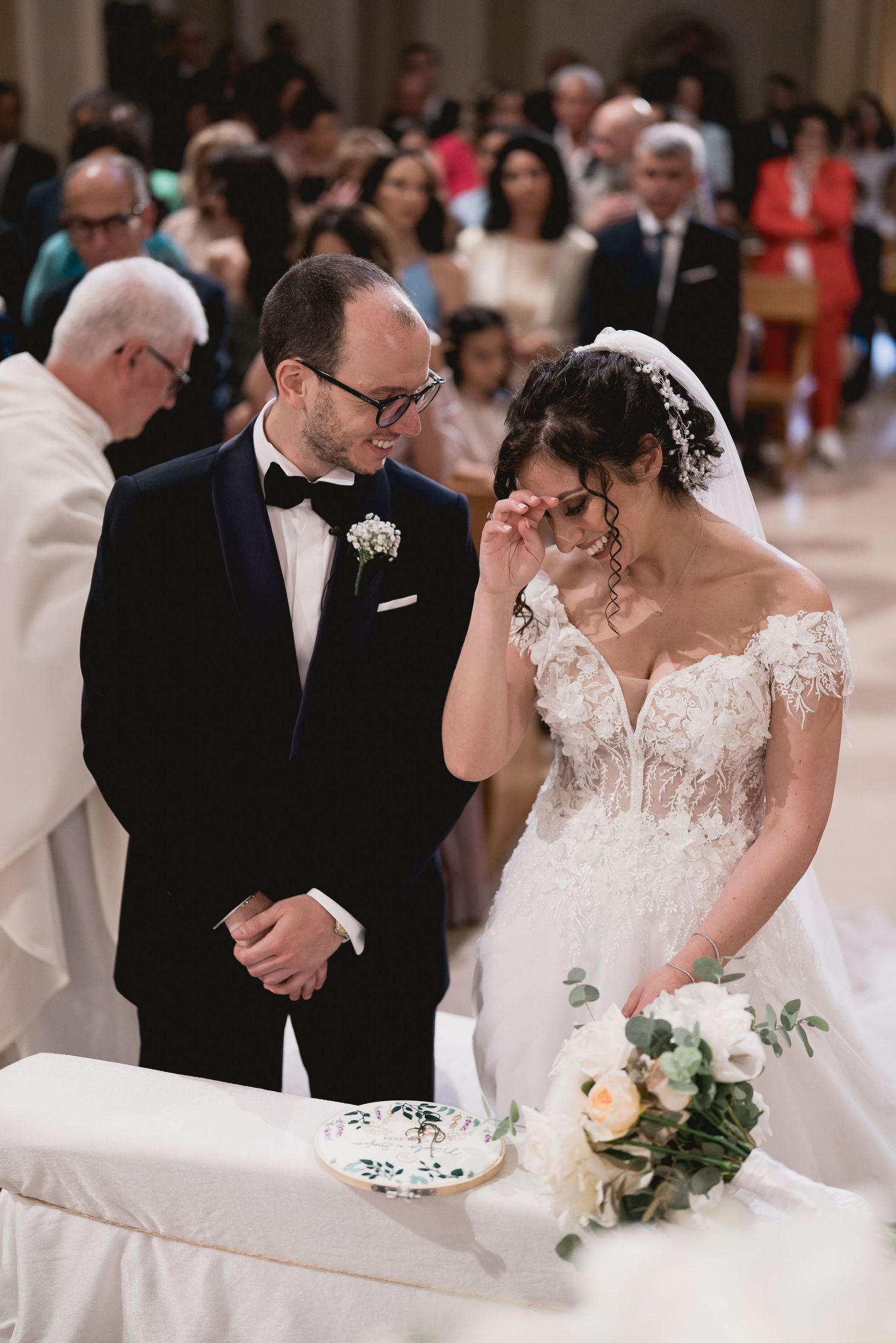 Emotional moment during a traditional church wedding ceremony with elegant floral decorations.