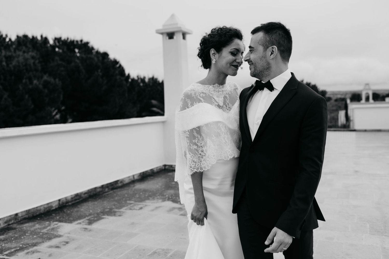 Black and white wedding portrait captured on a rooftop setting.