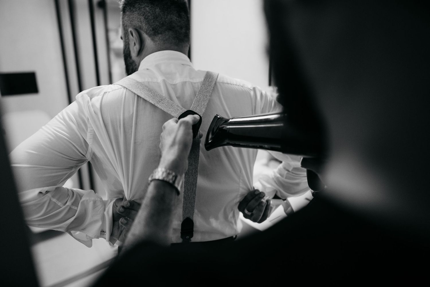 Close-up shot of someone adjusting formal white clothing in preparation for an event.