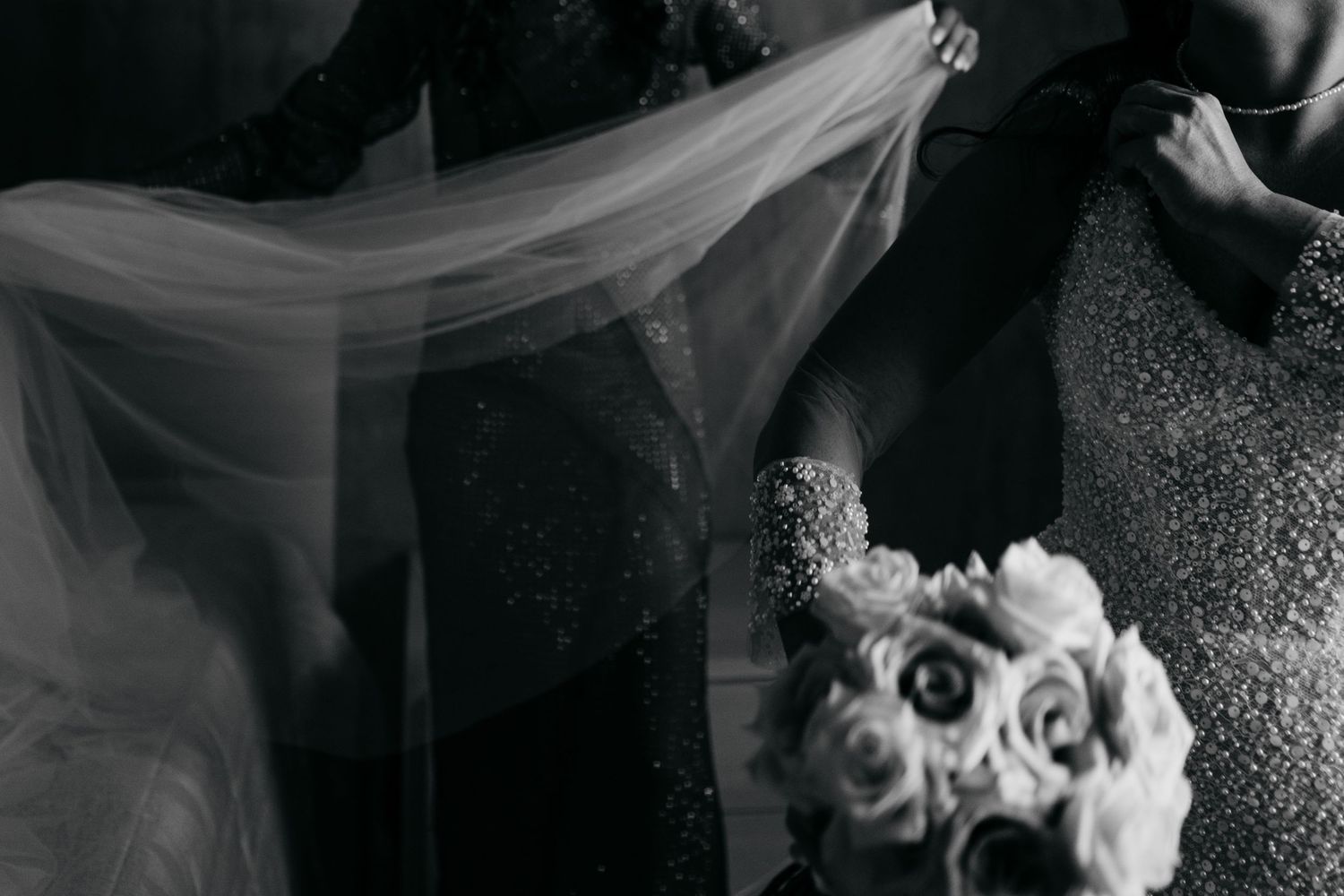 Black and white wedding photography with dramatic lighting and floral elements.