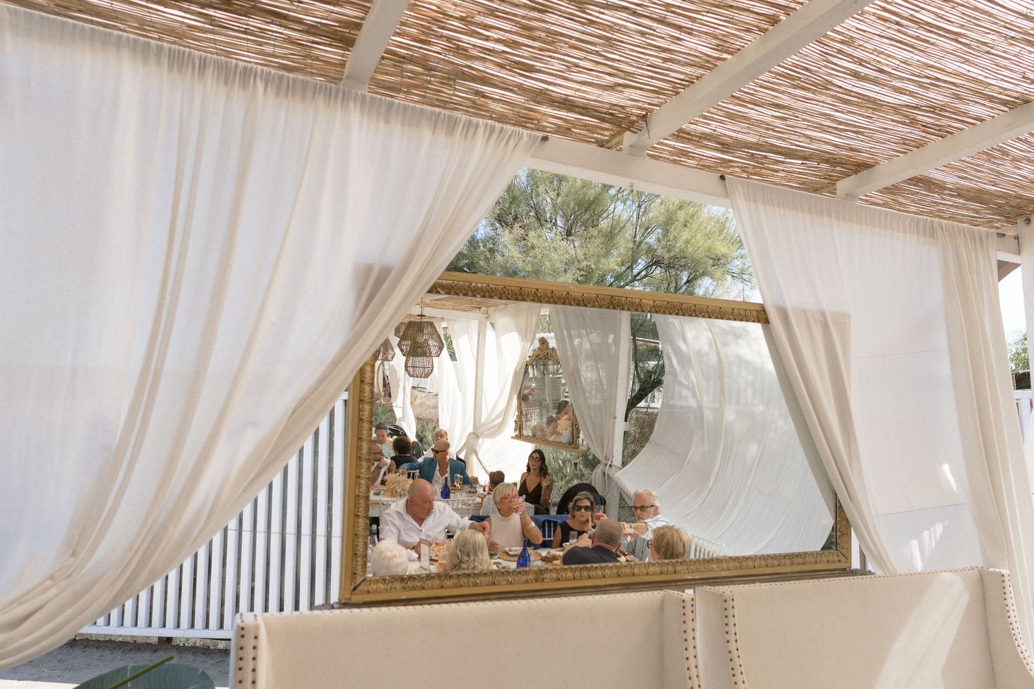 White fabric drapes create an elegant ceiling treatment at an outdoor wedding venue.