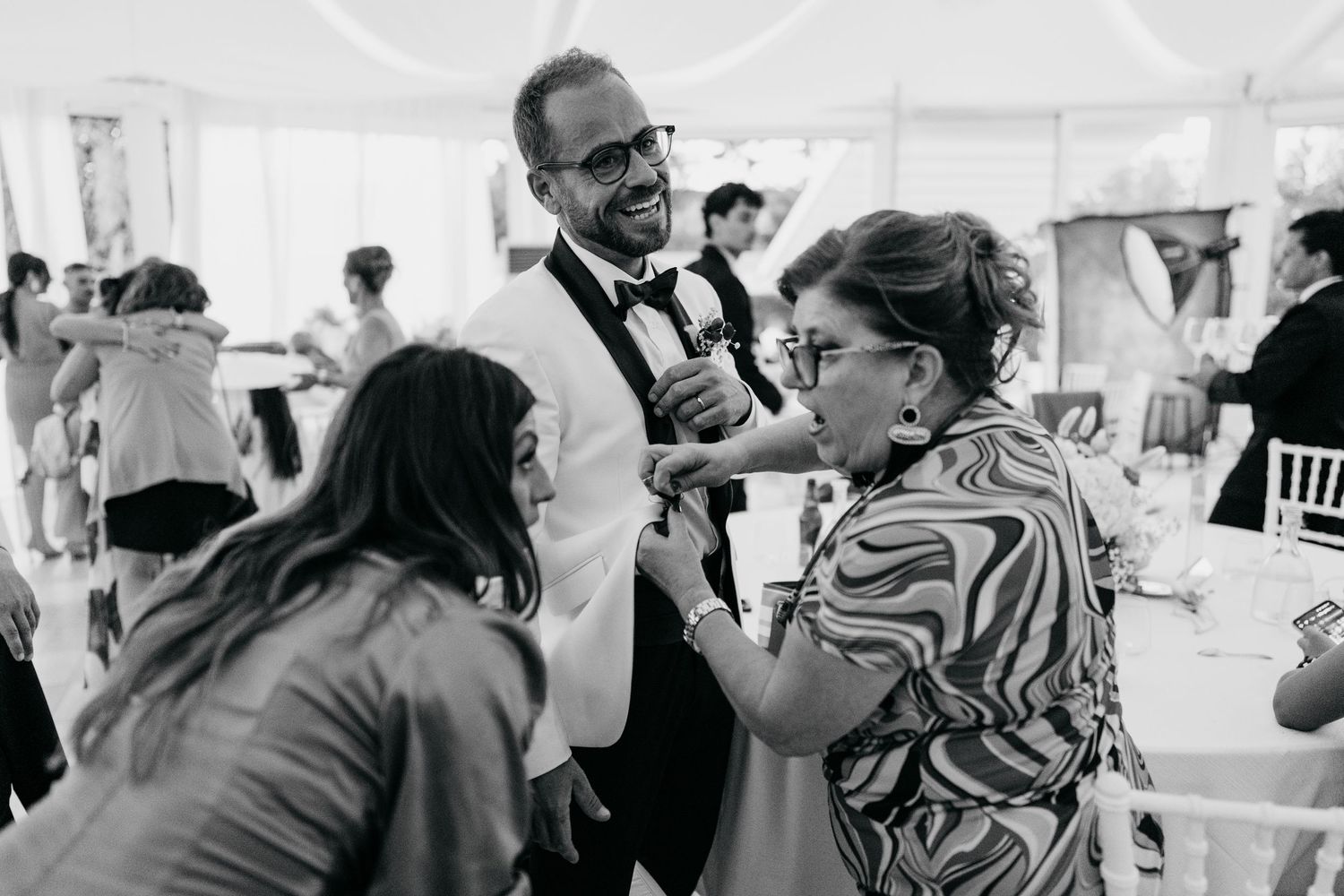 Wedding guests enjoying conversation and dancing at an indoor reception.