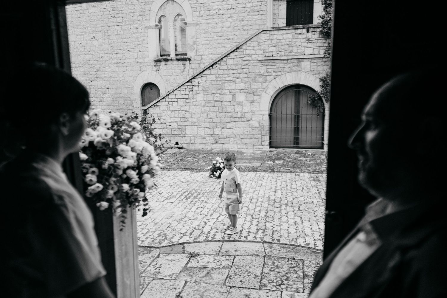 View through a stone archway of a historic building exterior with classic European architecture.