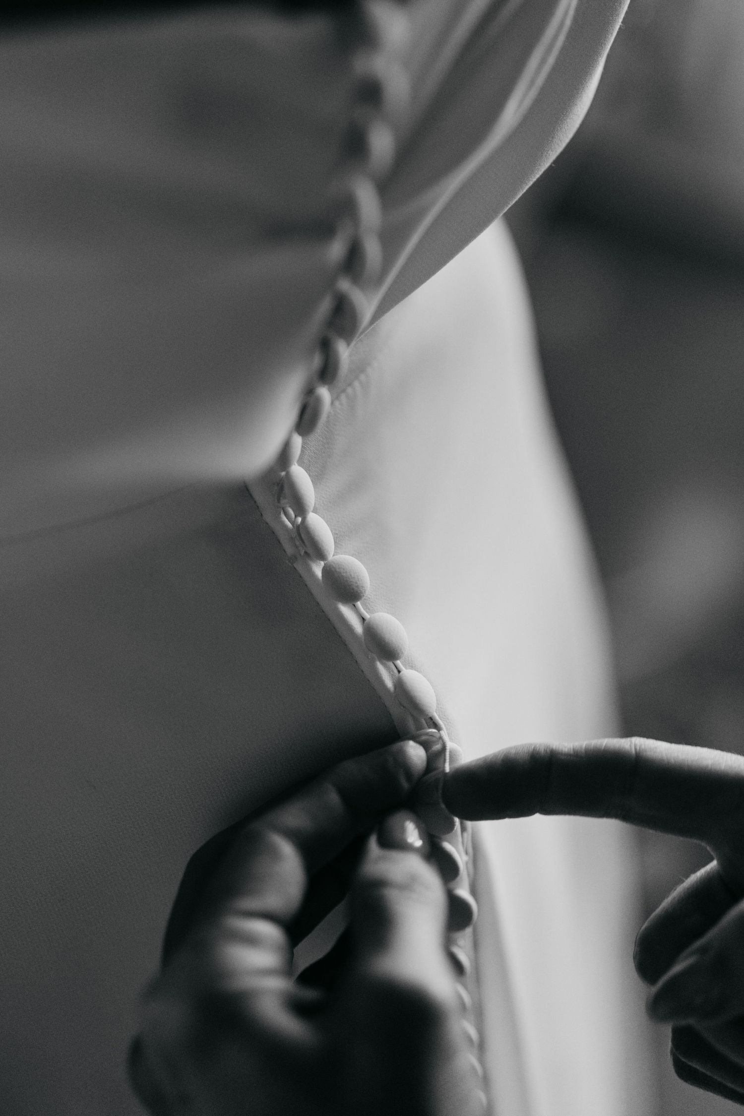 Close-up detail of white fabric with buttons in black and white.