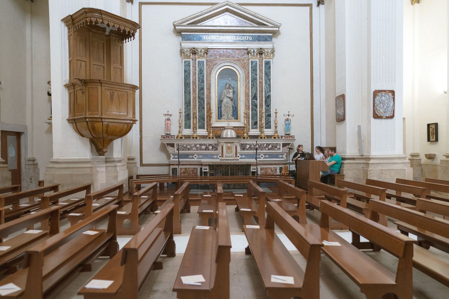 Traditional church interior with wooden pews and altar in symmetrical composition.