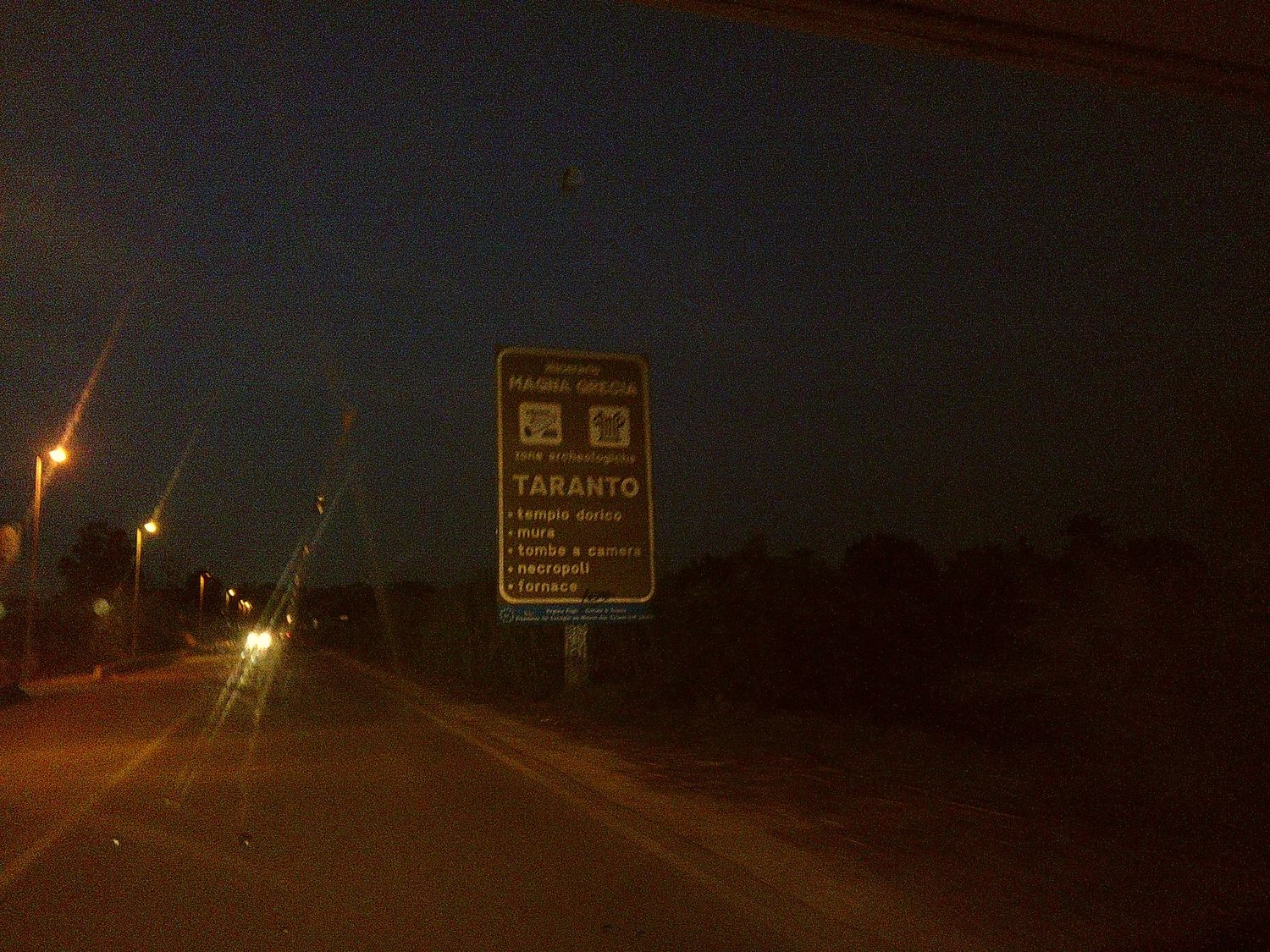 Road sign illuminated at night by street lights.