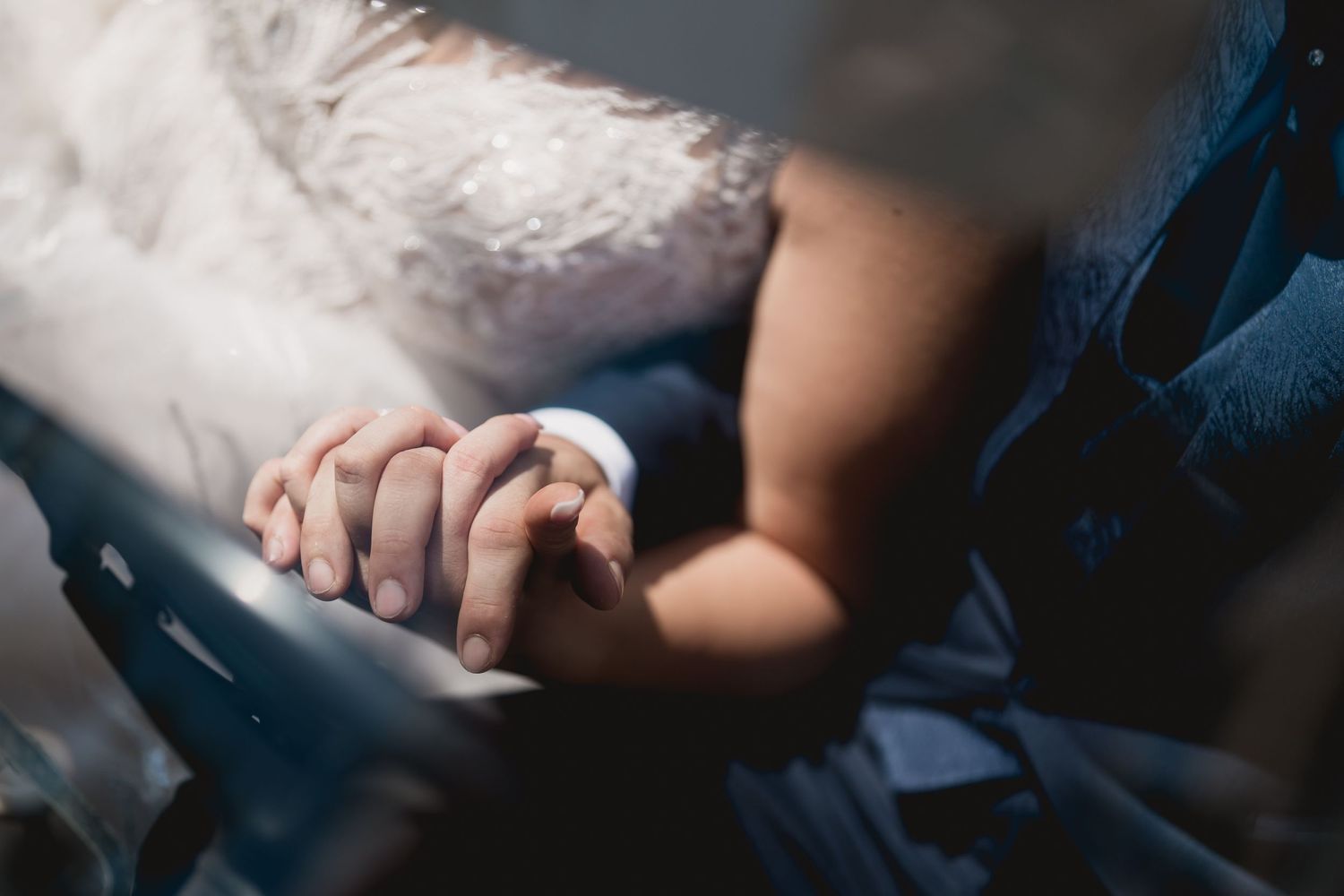 Close-up view of hands clasped together in an intimate moment.
