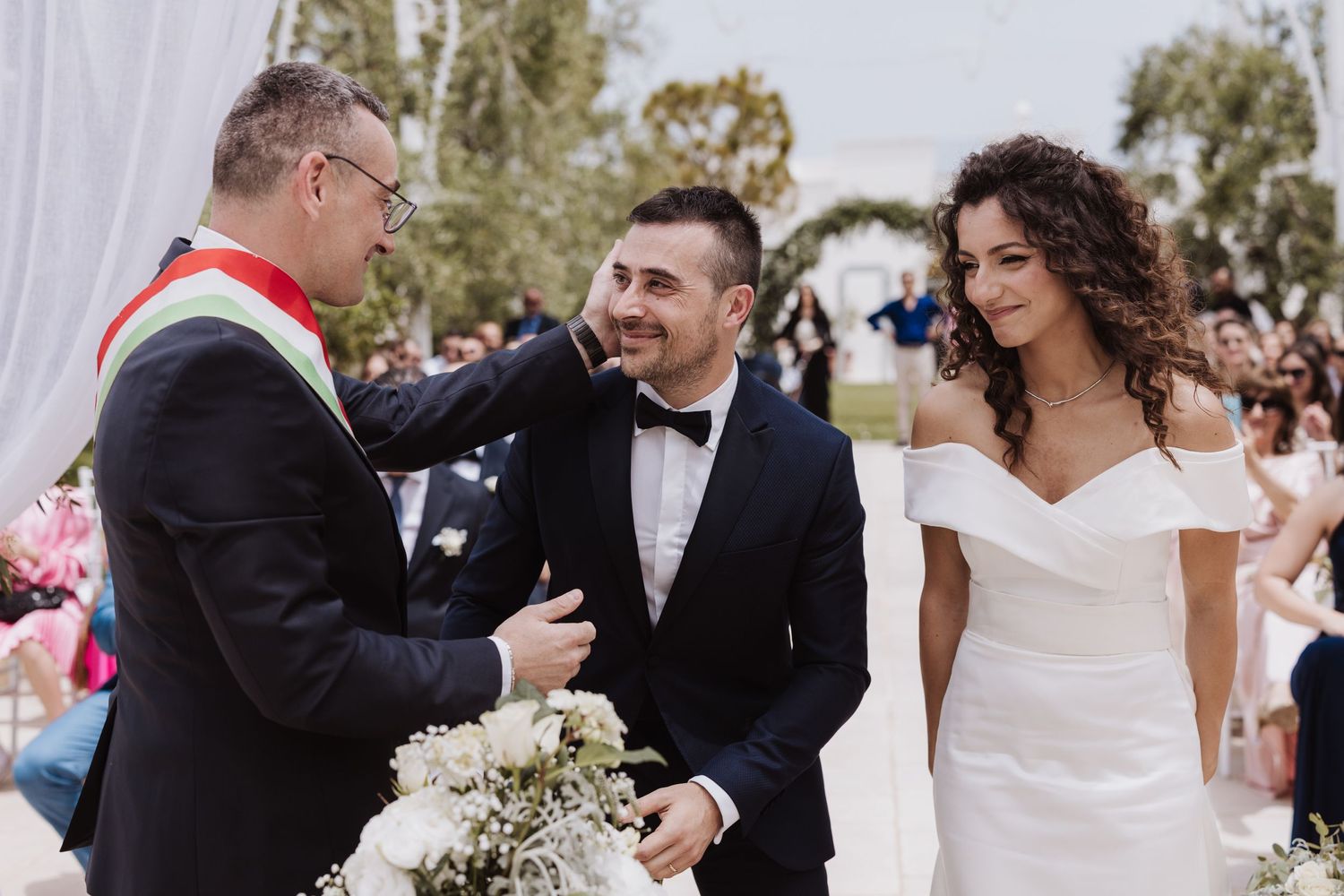 An outdoor wedding ceremony with an officiant speaking to the couple.