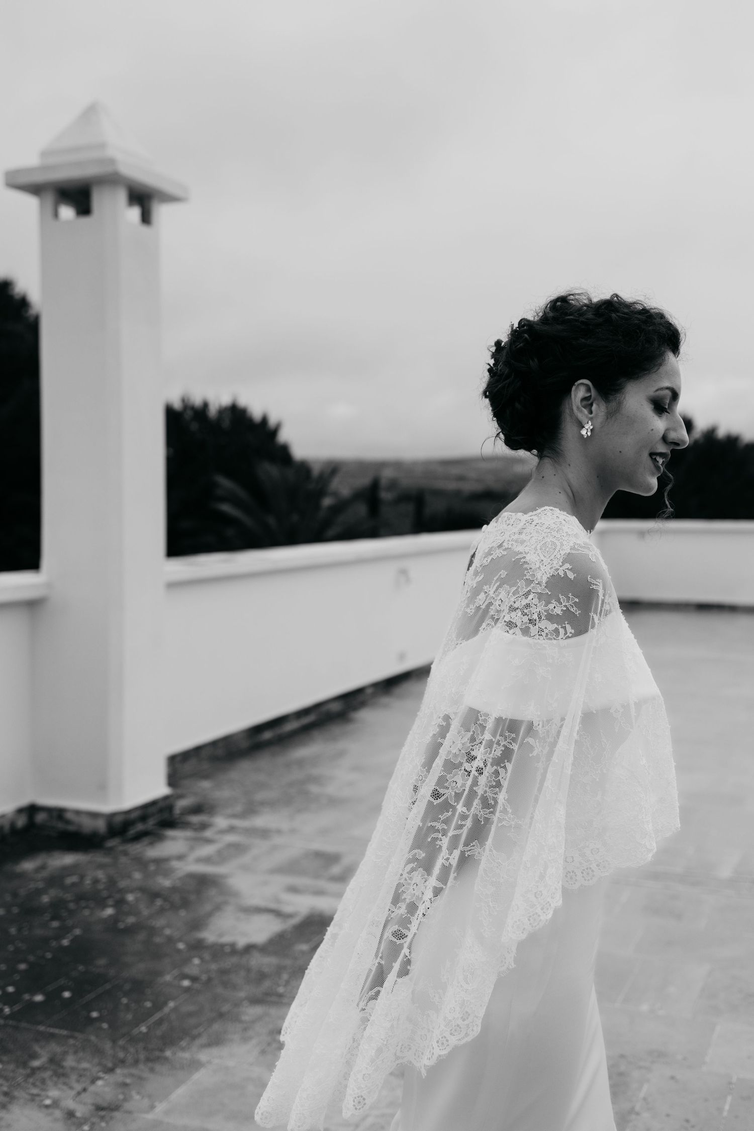Black and white profile shot of bride on rooftop with white architectural column.