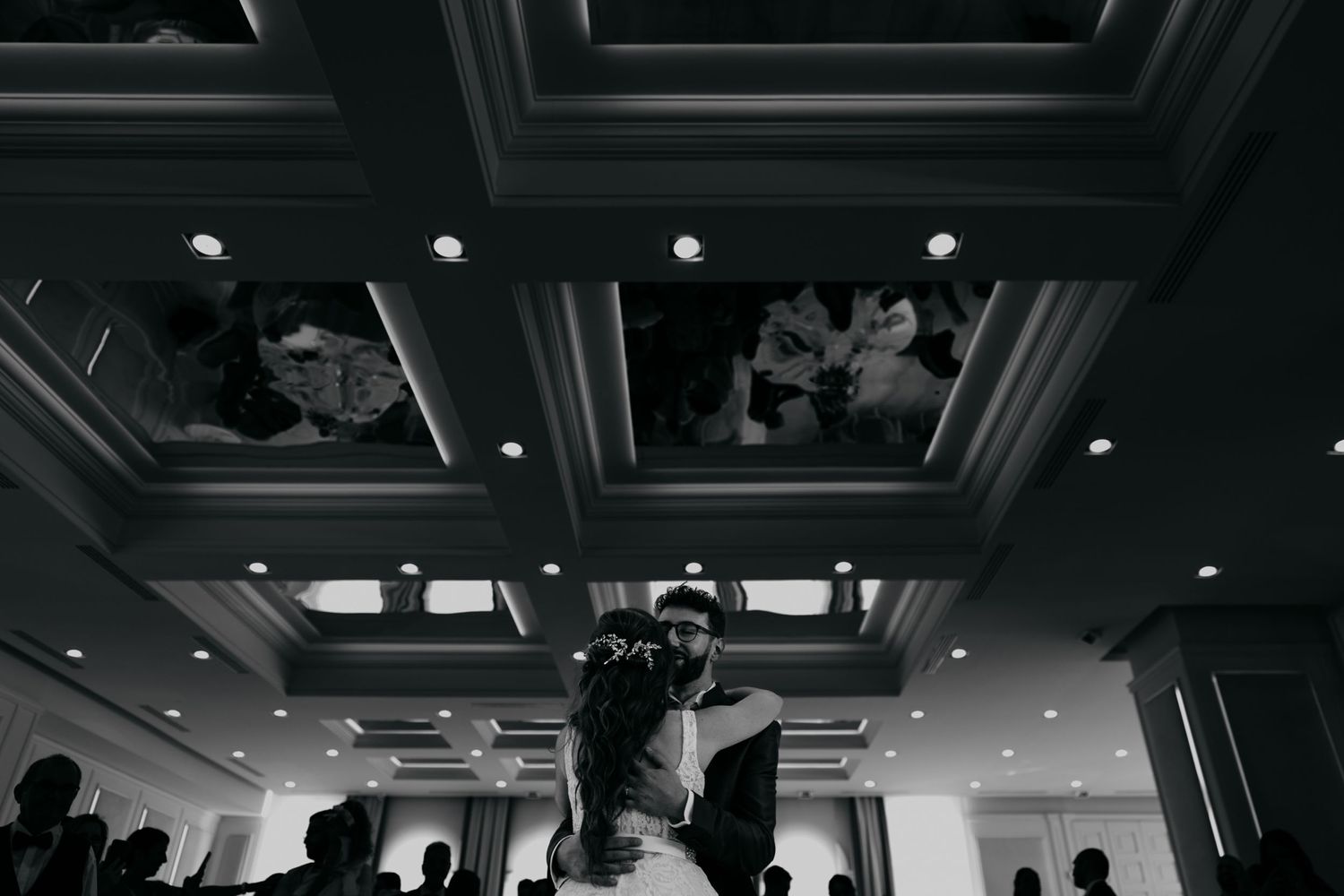 Black and white overhead shot of dancing couples at an elegant ballroom reception.