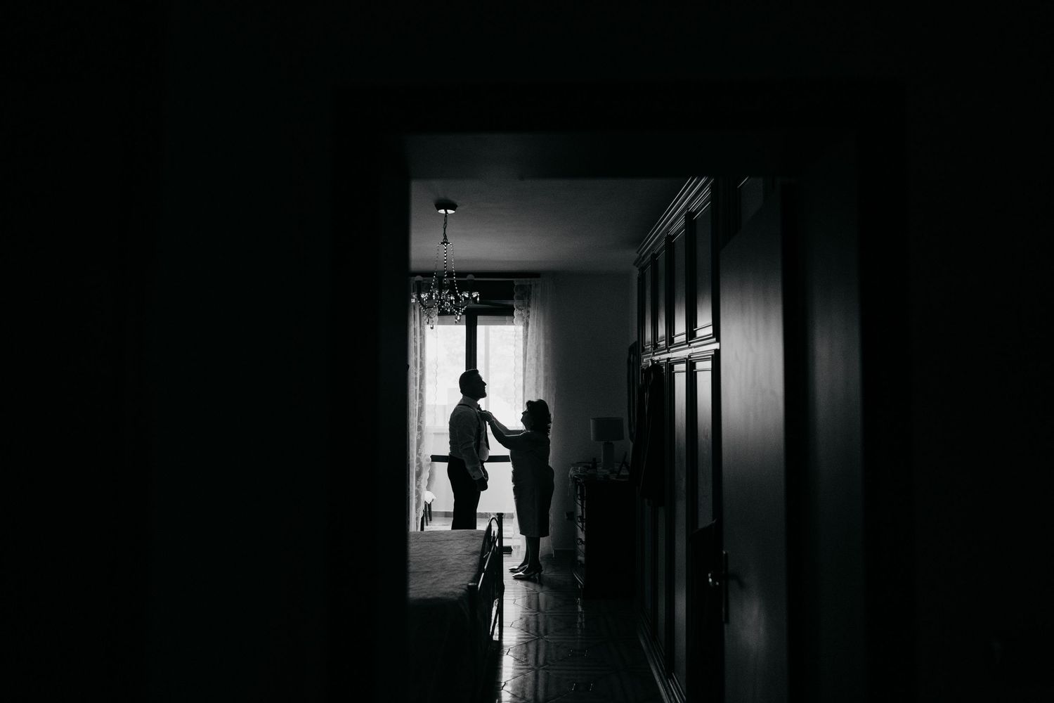Dark silhouettes of people walking through dimly lit hallways and corridors create a moody, atmospheric composition.