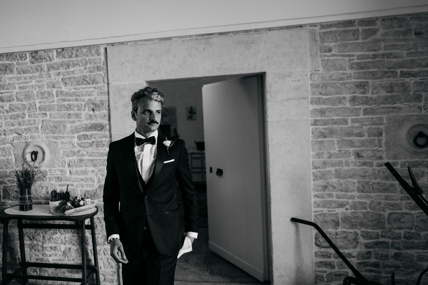 A formal event preparation scene in a brick-walled room with vintage decor.