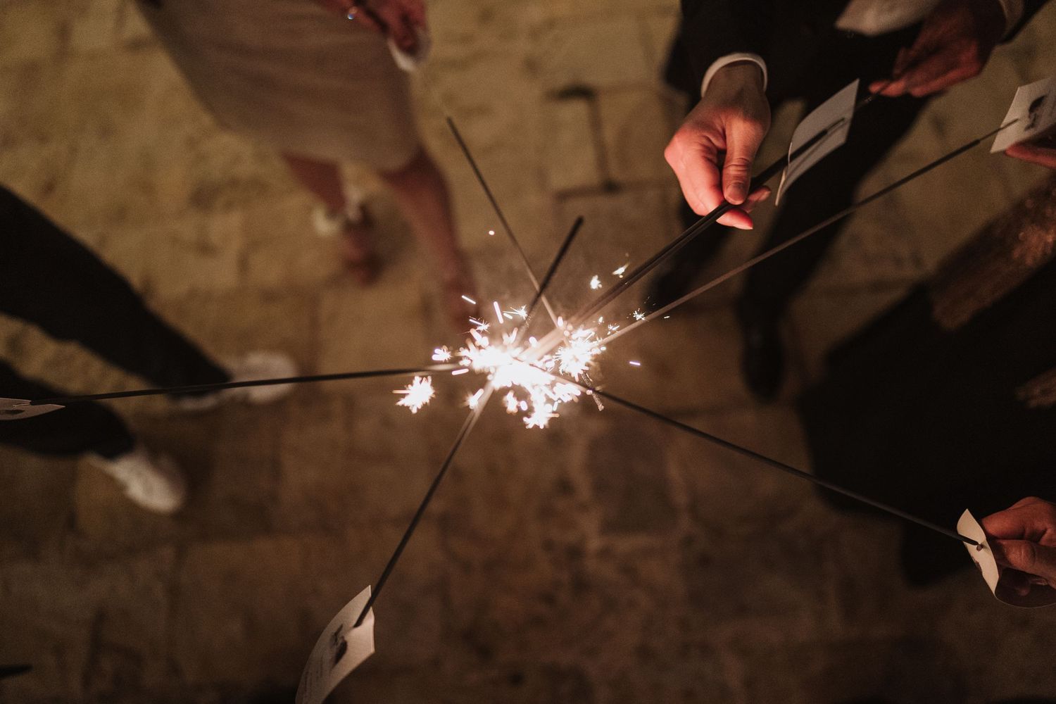 Multiple sparklers creating a magical light display against a dark background.