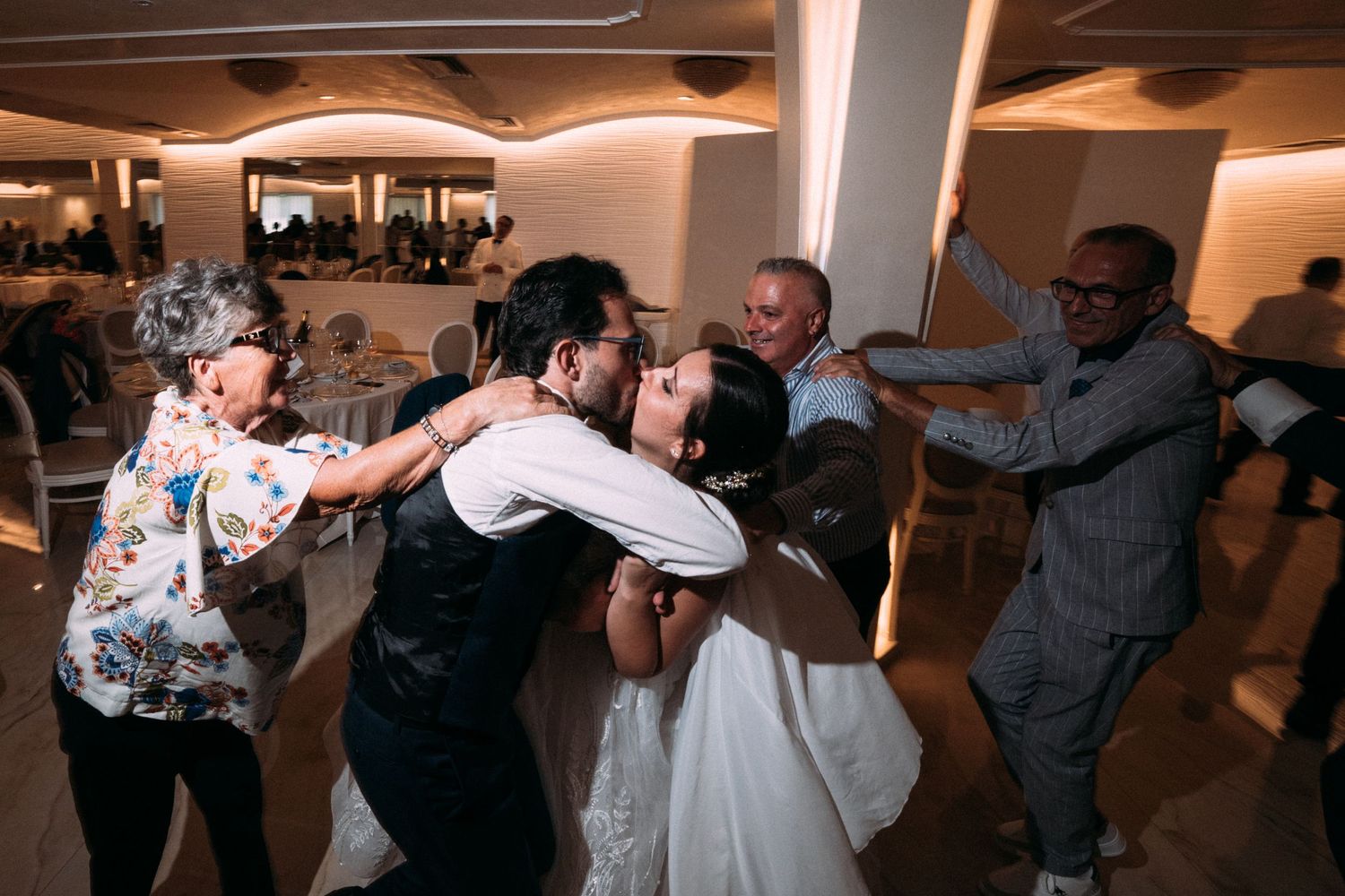 Wedding guests dancing and celebrating on the dance floor at a reception.